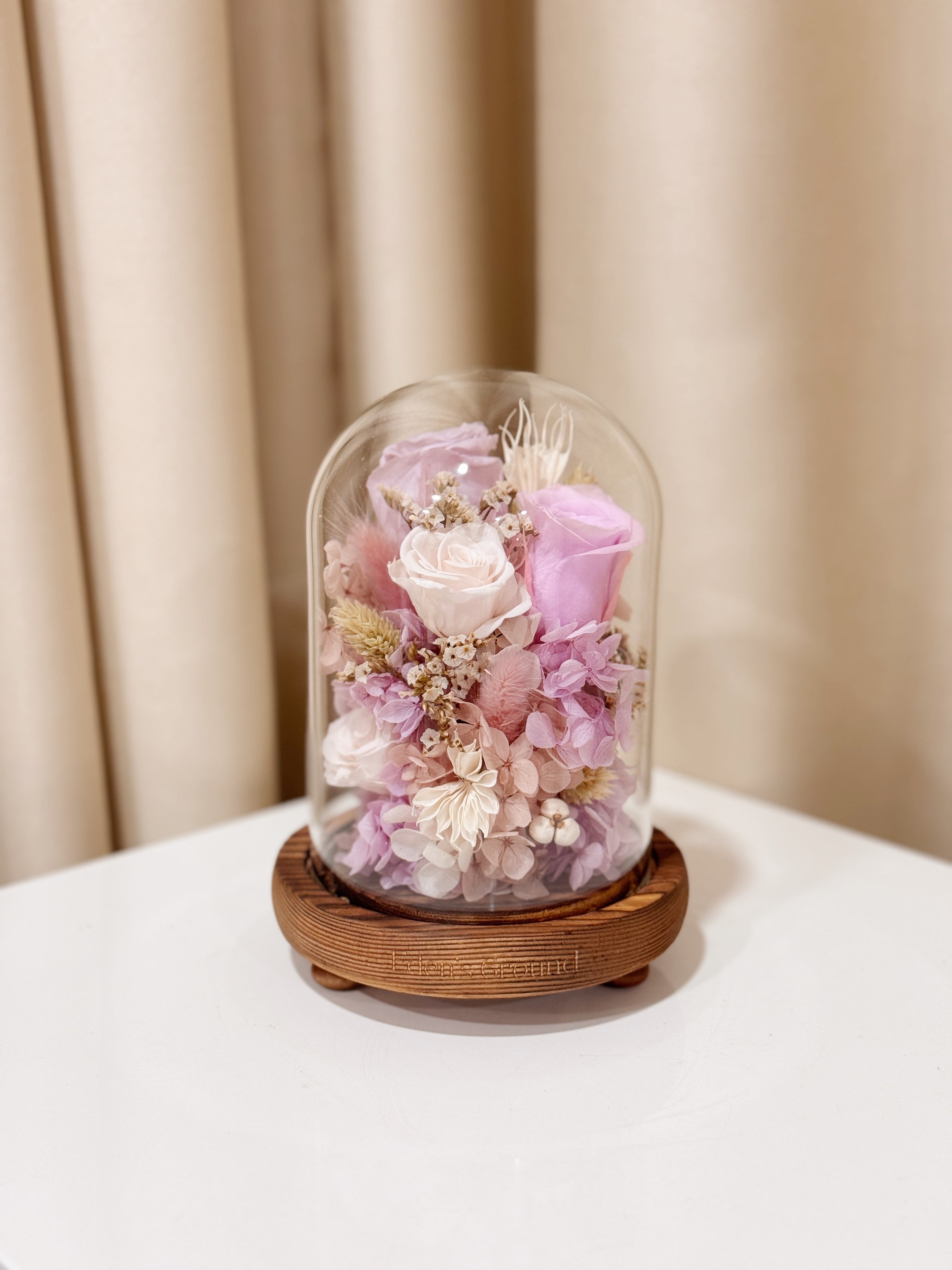 Everlasting Lilac Enchantment Flower Dome is made with a delicate blend of preserved lavender and purple roses, and flowers in a variety of soft pastel colours, beautifully arranged in a glass dome by Eden’s Ground—an unforgettable gift or home decor made to last.