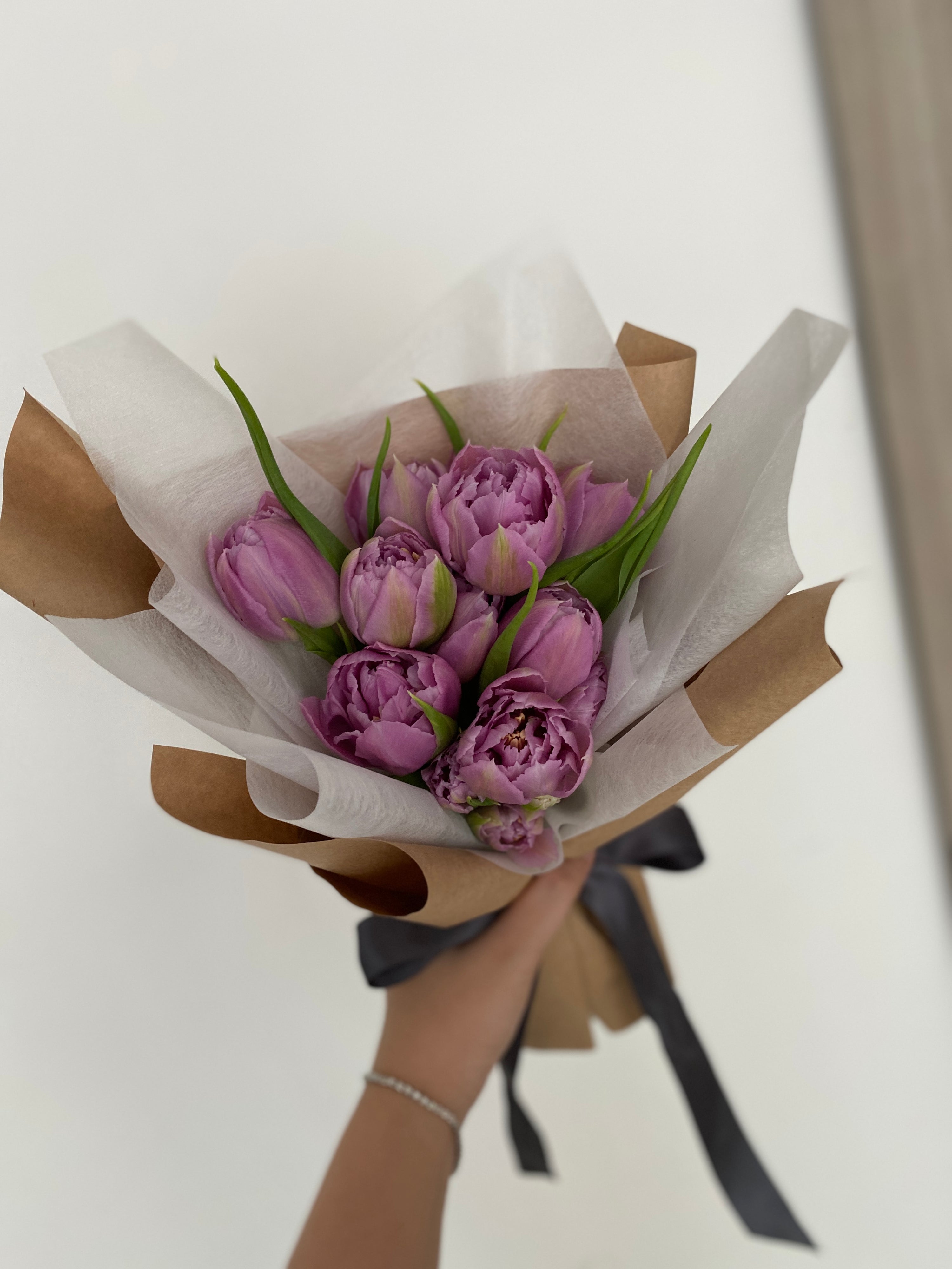 Classic tulip bouquet wrapped in tissue paper and brown kraft paper crafted by Eden’s Ground.