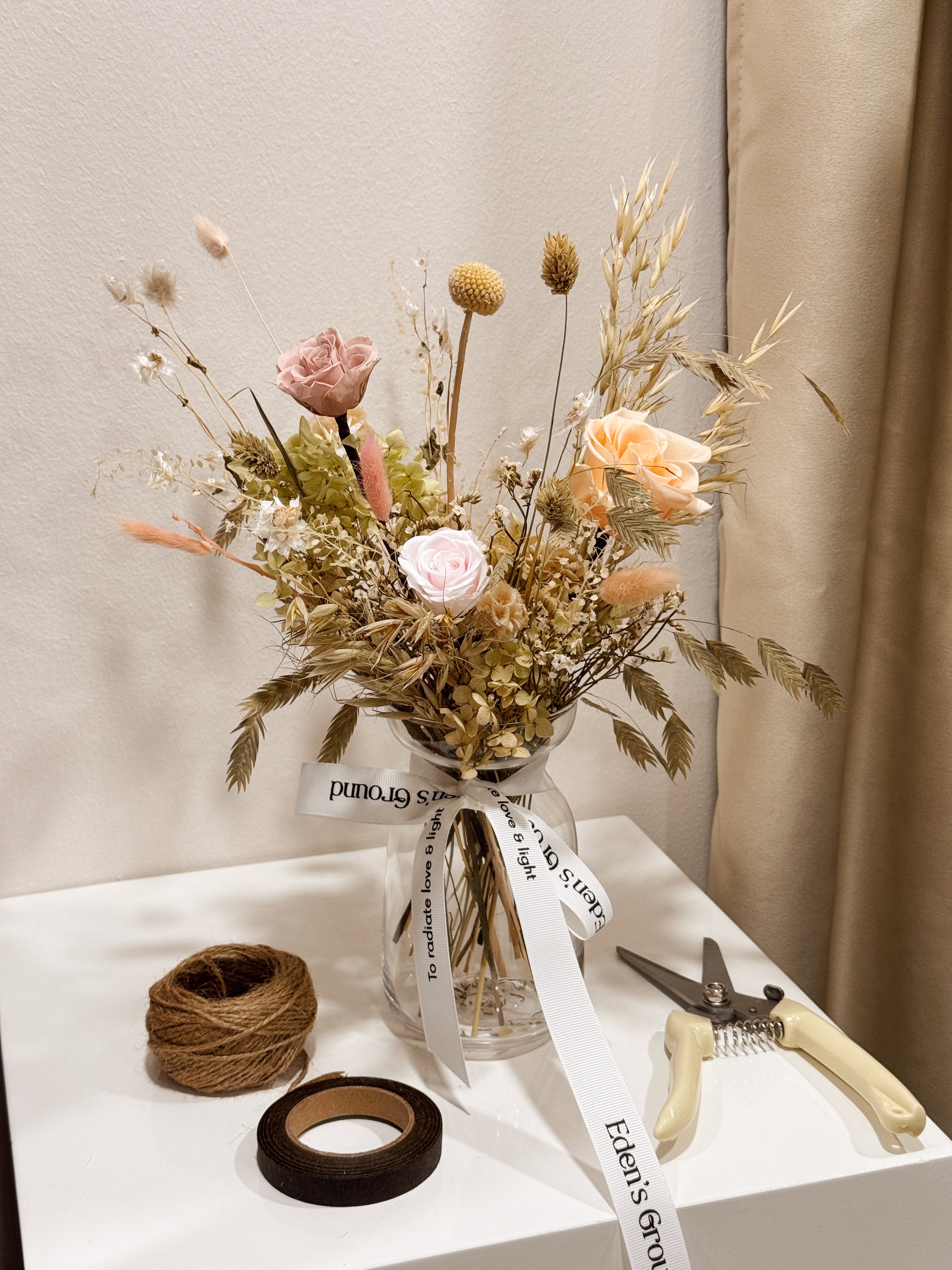 A preserved and dried flower vase arrangement workshop, in soft green and neutral tones. Guided by Eden's Ground, a floral design boutique.