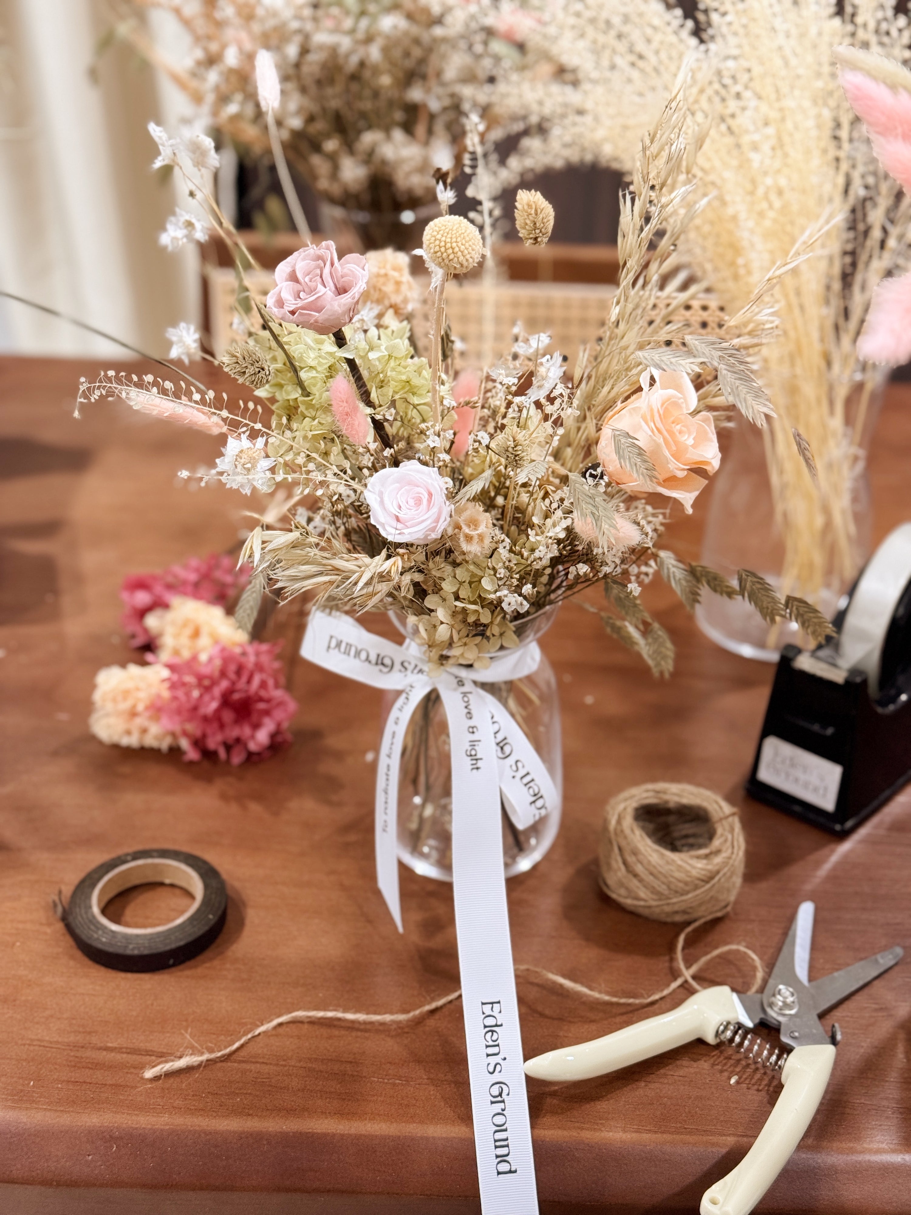 A preserved and dried flower vase arrangement workshop, in soft green and neutral tones. Guided by Eden's Ground, a floral design boutique.