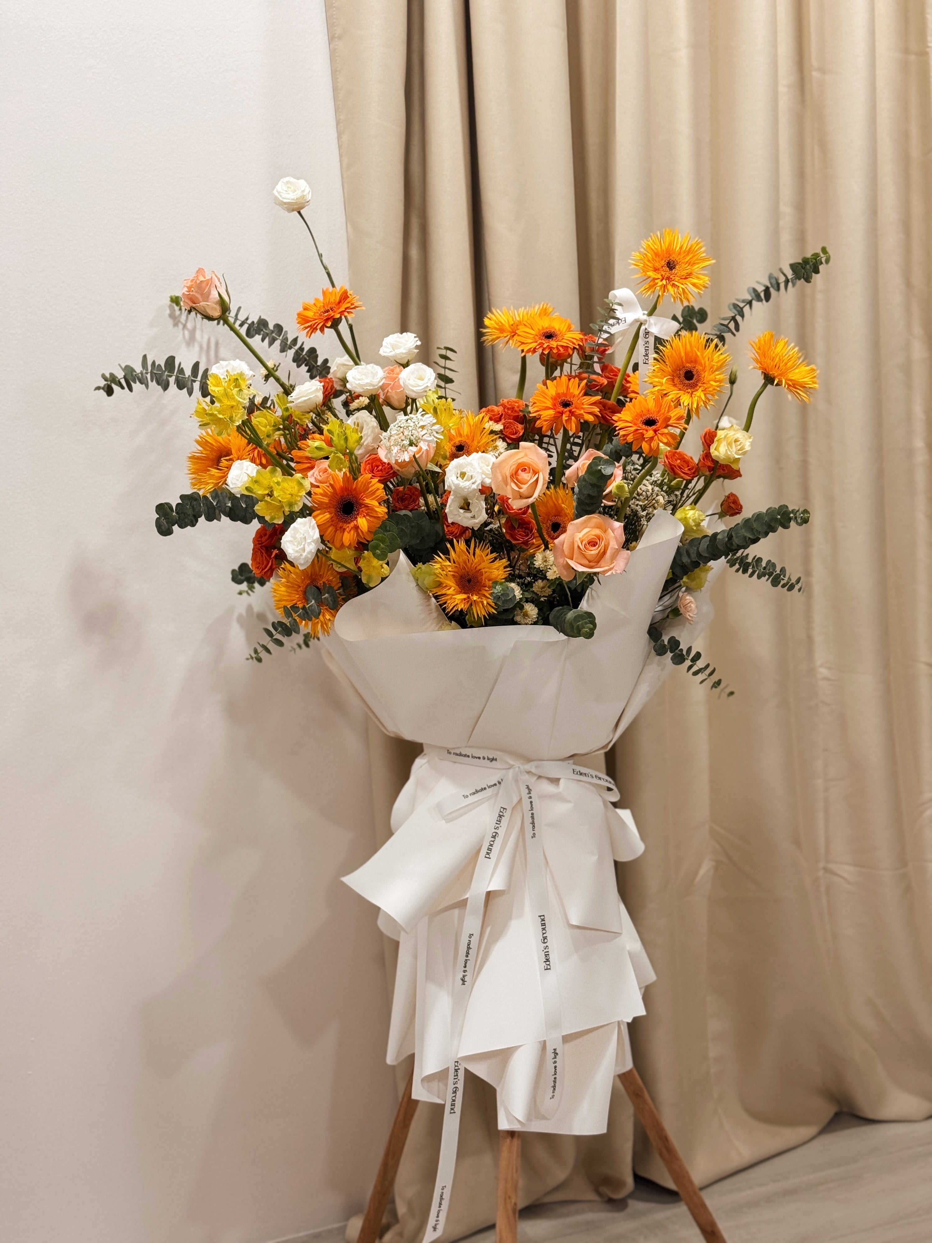 Warmest Congratulations, Fresh Flower Congratulatory Stand, featuring vibrant Roses, cheerful Gerbera, and the fresh touch of eucalyptus, crafted by Eden's Ground, a floral design boutique based in Singapore.