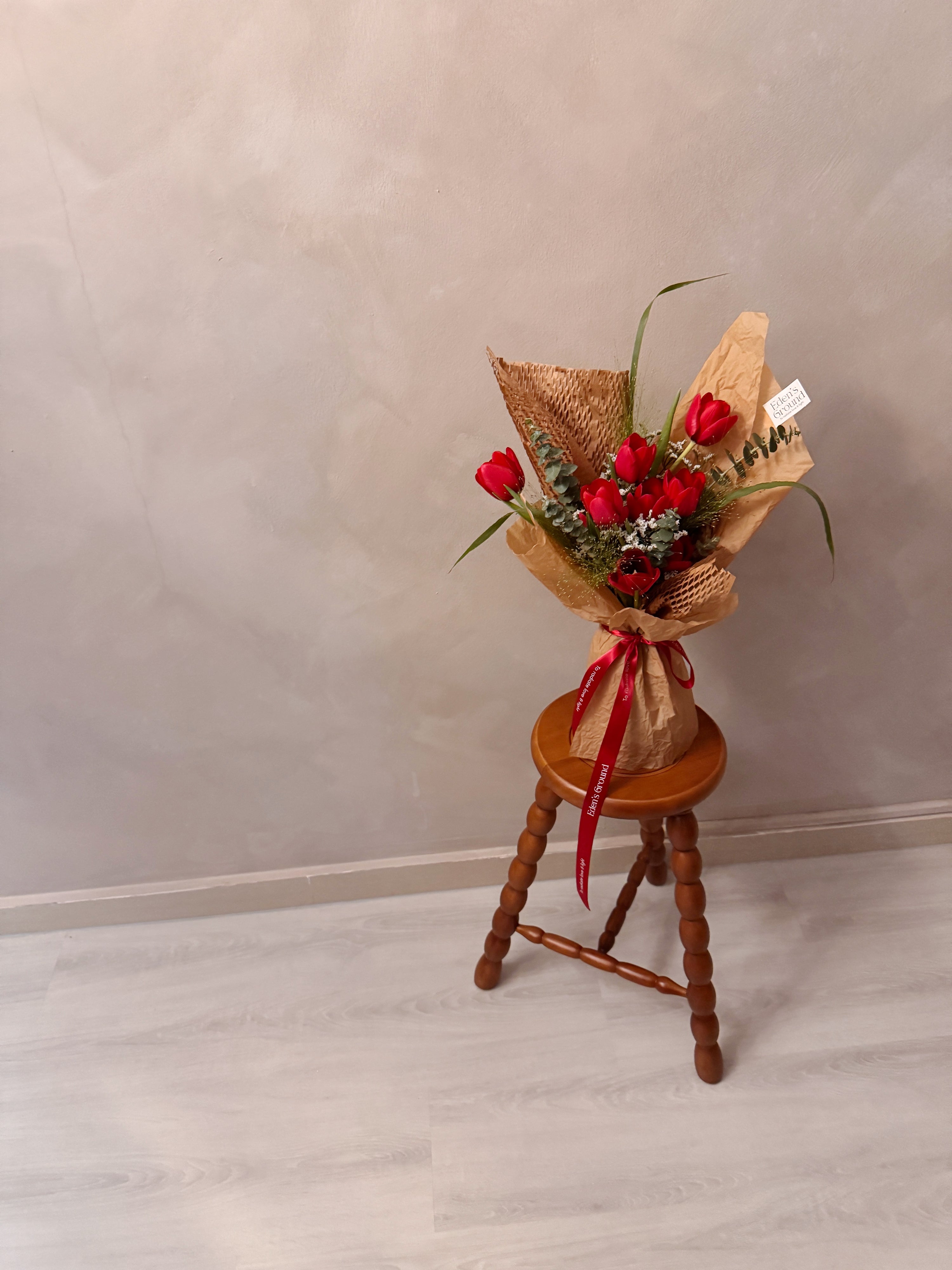Sweetest Love bouquet featuring vibrant red tulips with lots of textural foliage such as eucalyptus, wrapped in brown honeycomb and kraft paper crafted by Eden’s Ground, a floral design boutique based in Singapore.