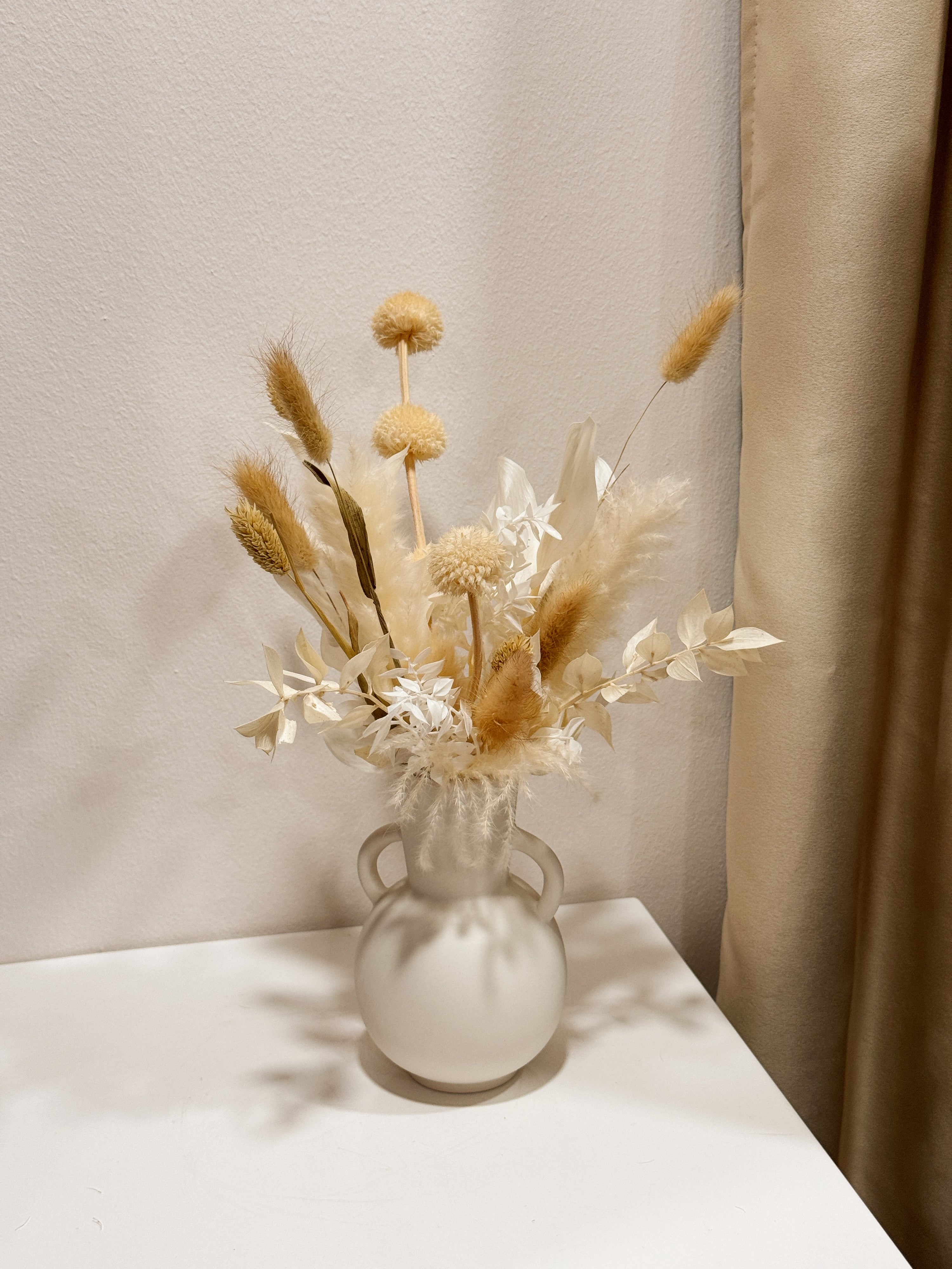 The Alabaster Field vase arrangement by Eden’s Ground featuring everlasting florals in soft, earthy tones — thoughtfully styled in a matte porcelain vase. Low-maintenance and long-lasting, it's perfect as a housewarming gift or as a timeless piece of home décor.