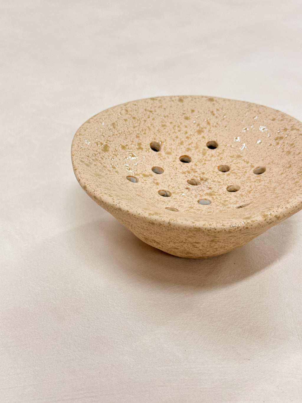 White ceramic Ikebana Japanese inspired potting tool with holes for floral arranging.