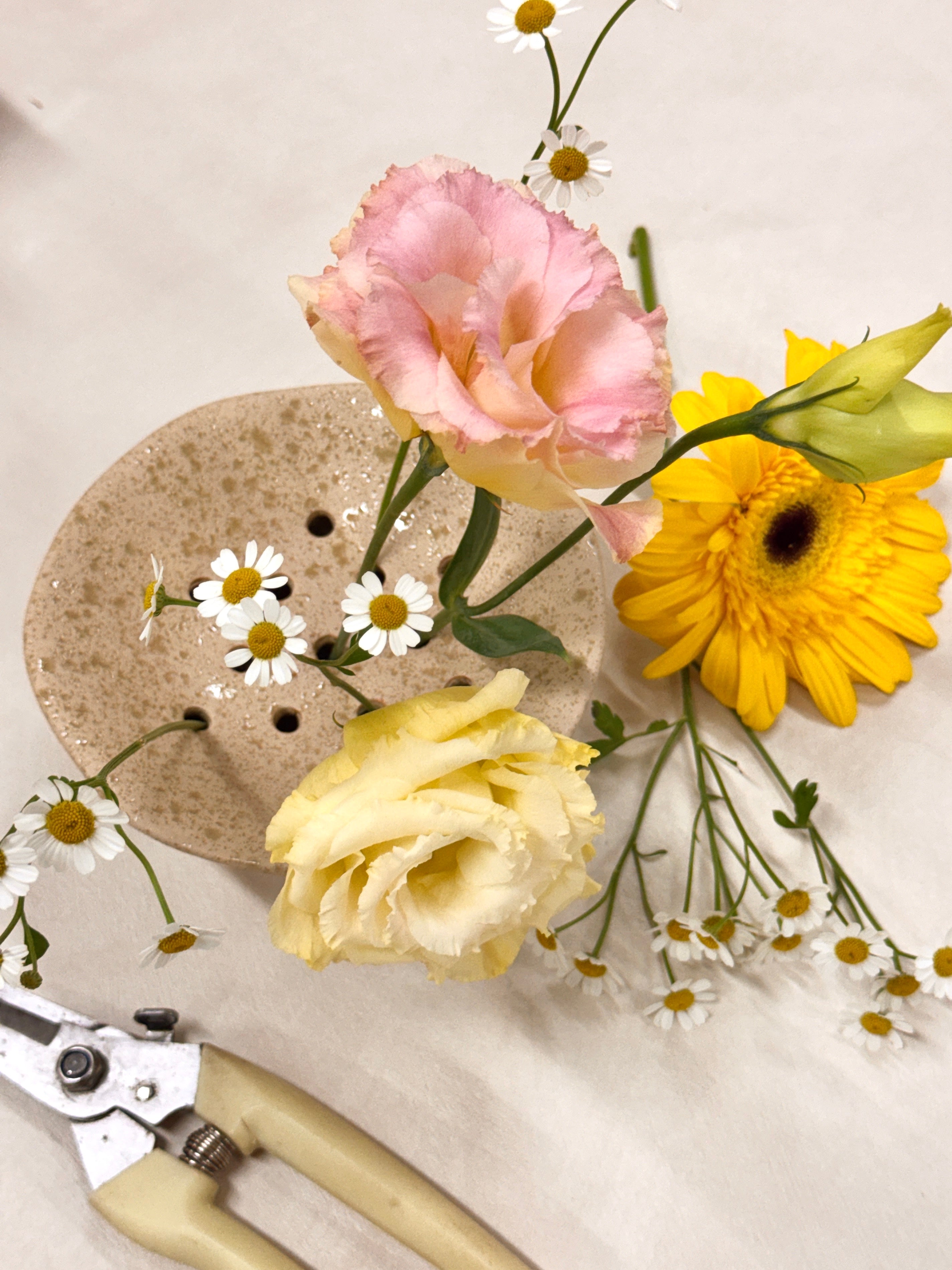 White ceramic Ikebana Japanese inspired potting tool with holes for floral arranging.