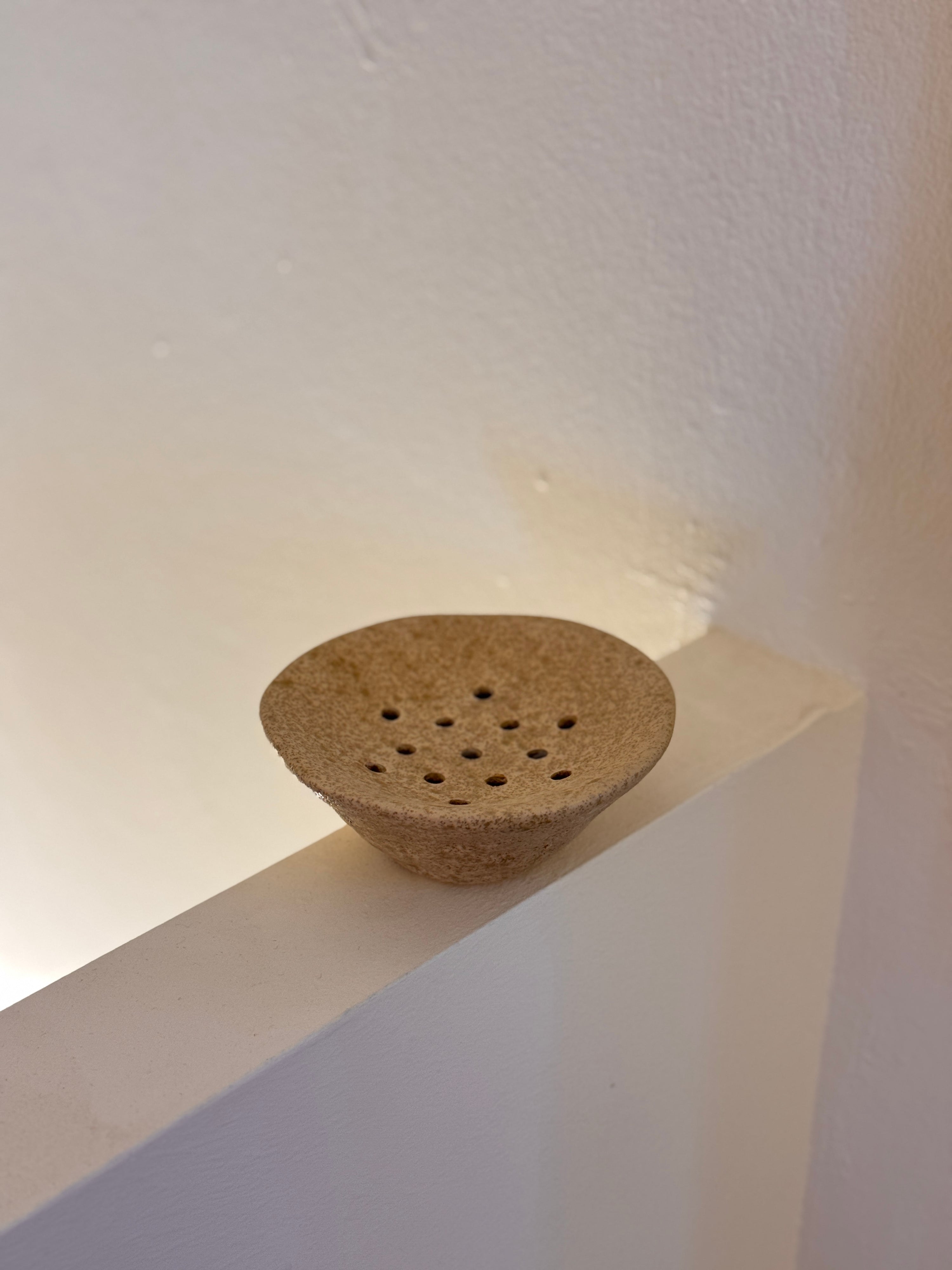 White ceramic Ikebana Japanese inspired potting tool with holes for floral arranging.