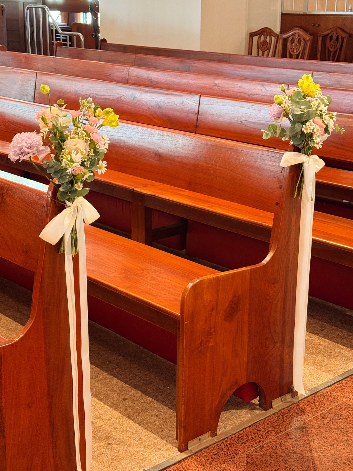 Church aisle pew flowers, craffted with fresh flowers by Eden's Ground, a floral design boutique.