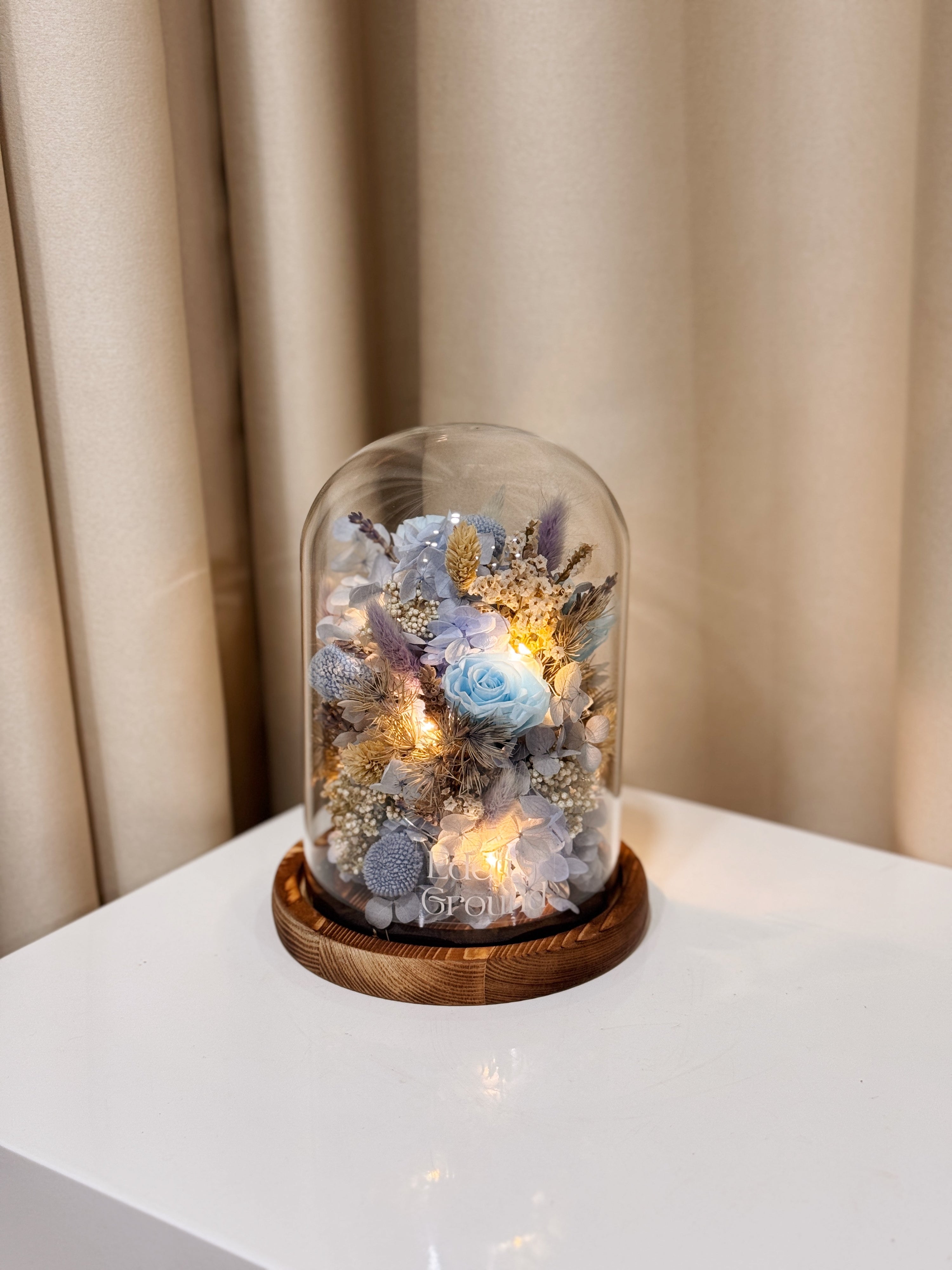 Cloud Garden Preserved Flower Dome is made with a delicate blend of preserved and dried flowers in shades of blue, beautifully arranged in a glass dome by Eden’s Ground—an unforgettable gift or home decor made to last. 