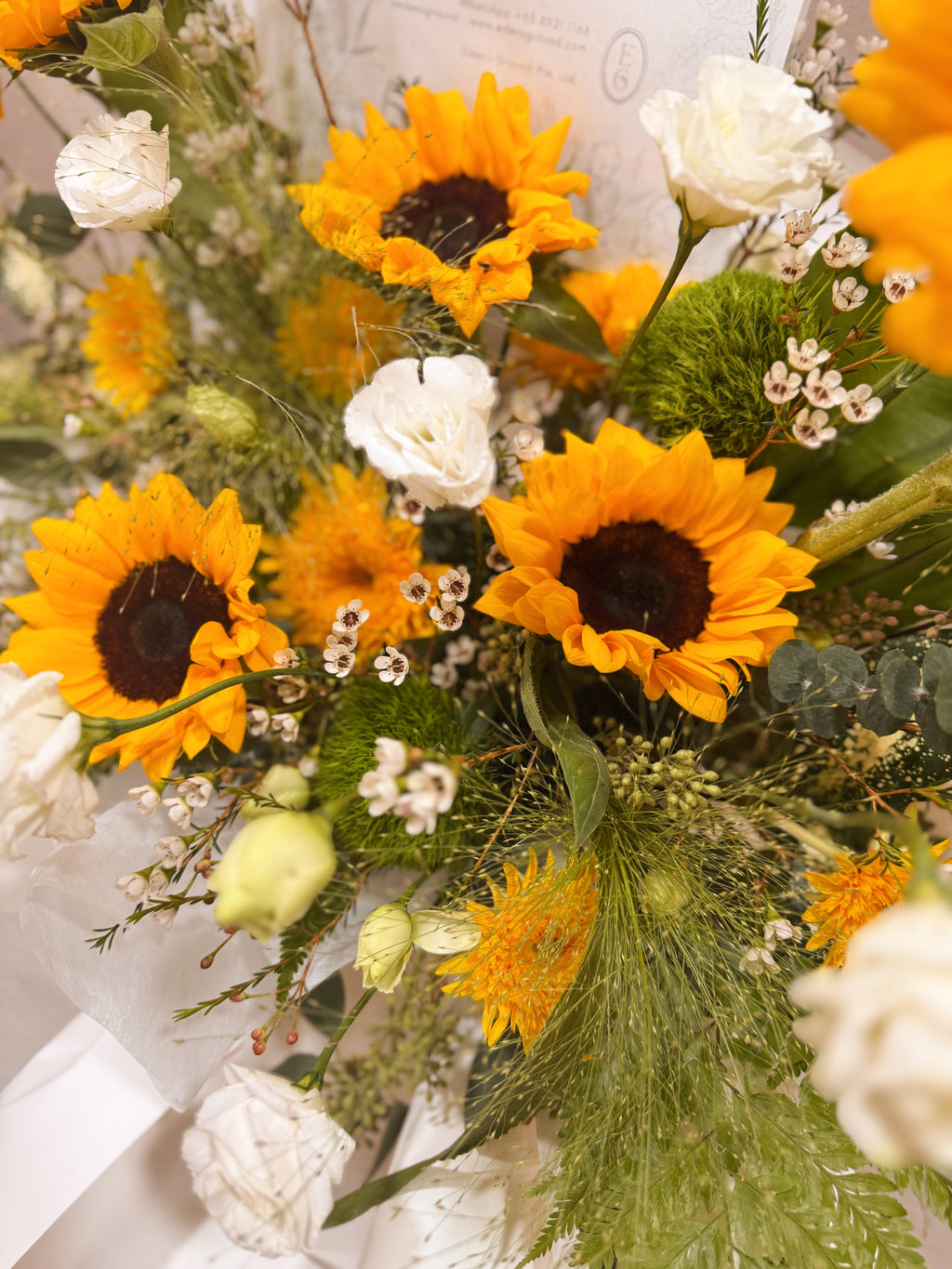 Shining Success Sunflower Congratulatory Stand, featuring vibrant Sunflowers, and the fresh touch of eucalyptus, crafted by Eden's Ground, a floral design boutique based in Singapore.