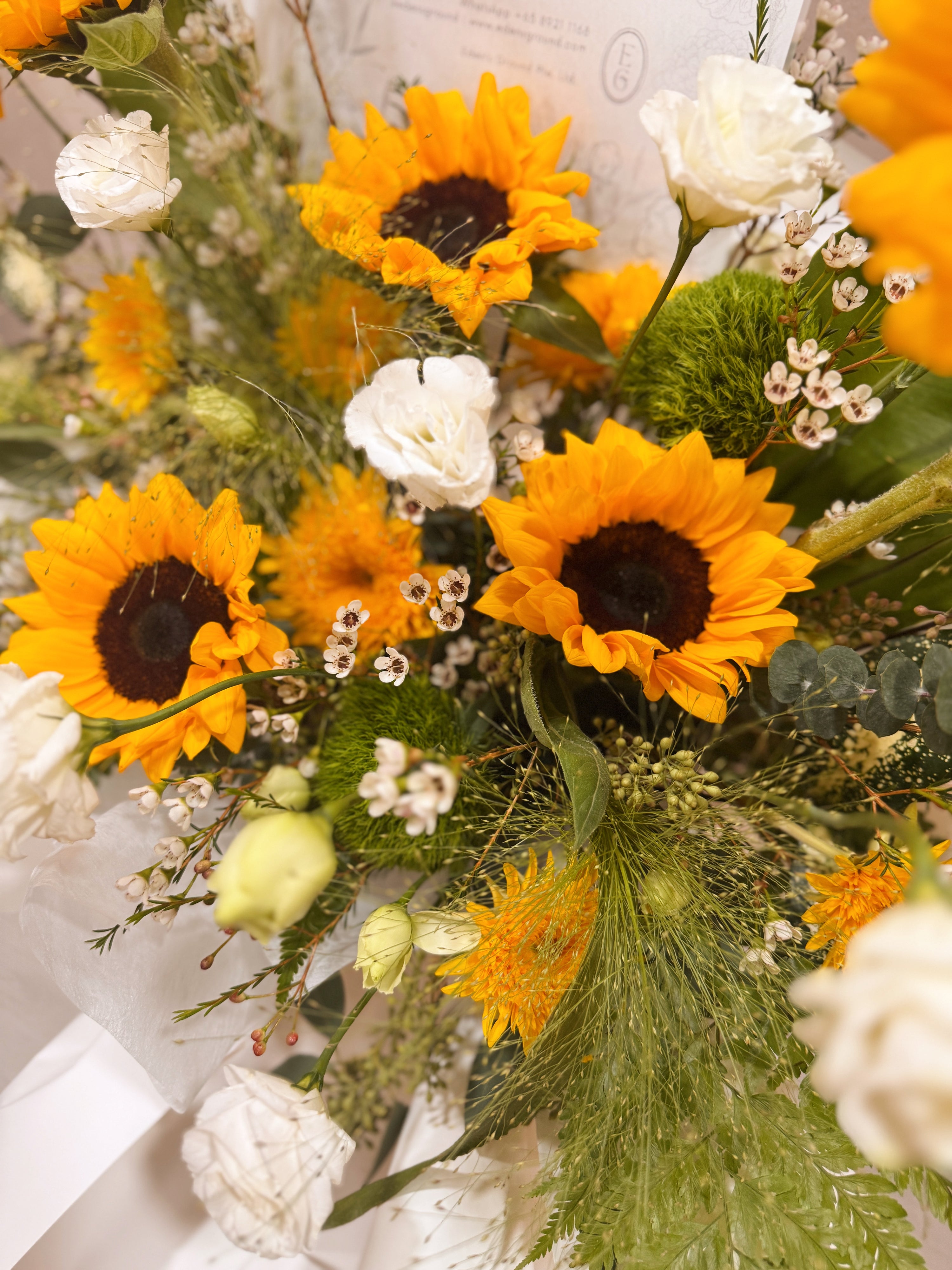 Shining Success Sunflower Congratulatory Stand, featuring vibrant Sunflowers, and the fresh touch of eucalyptus, crafted by Eden's Ground, a floral design boutique based in Singapore.