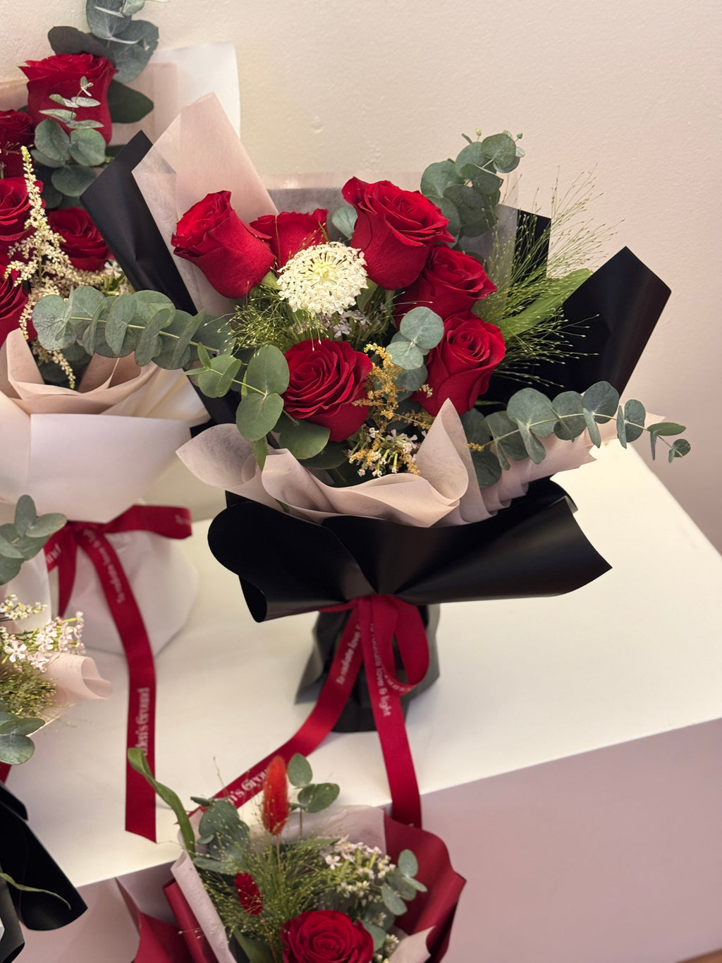 Crimson Garden red roses bouquet wrapped in white, red, or black glassine paper crafted by Eden’s Ground. A classic Valentine's day bouquet.