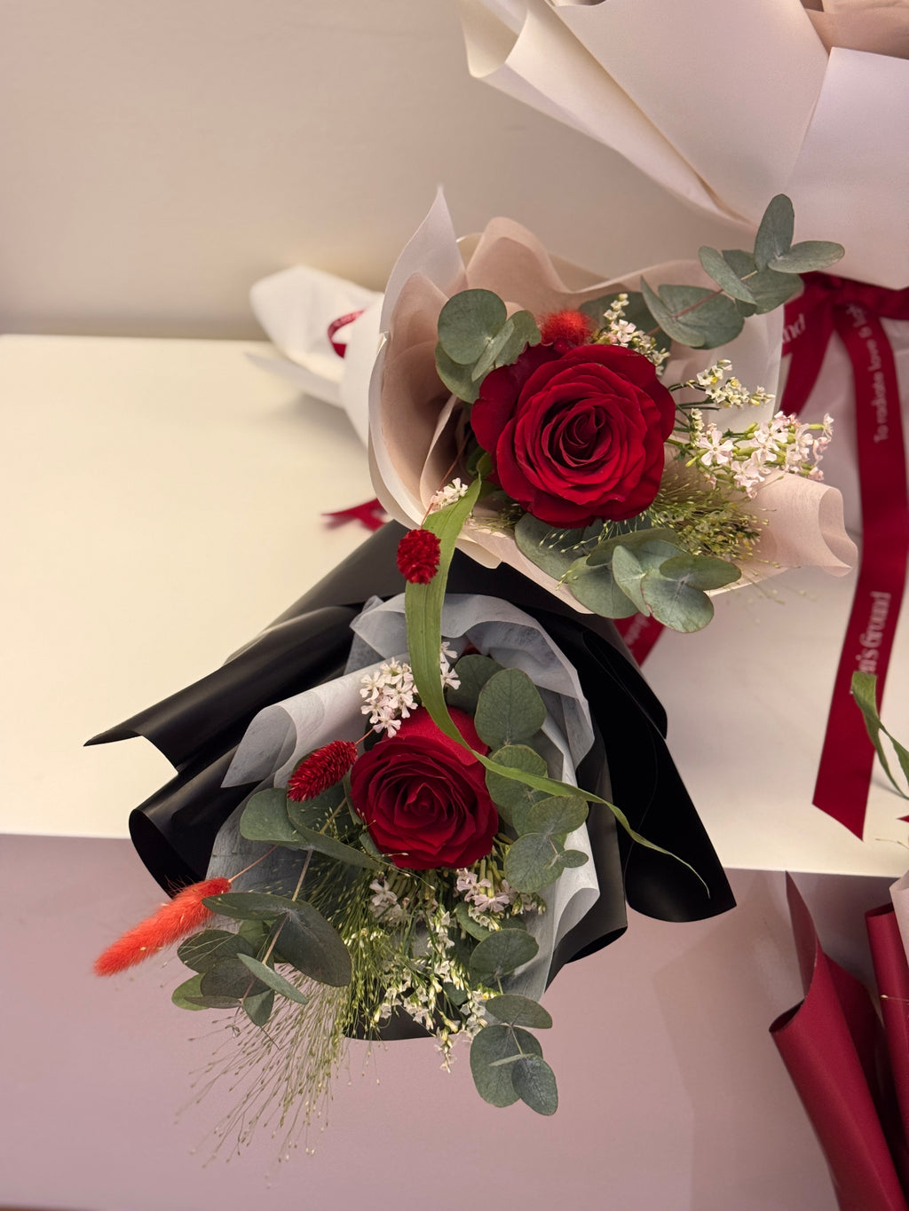 Crimson Garden red roses bouquet wrapped in white, red, or black glassine paper crafted by Eden’s Ground. A classic Valentine's day bouquet.