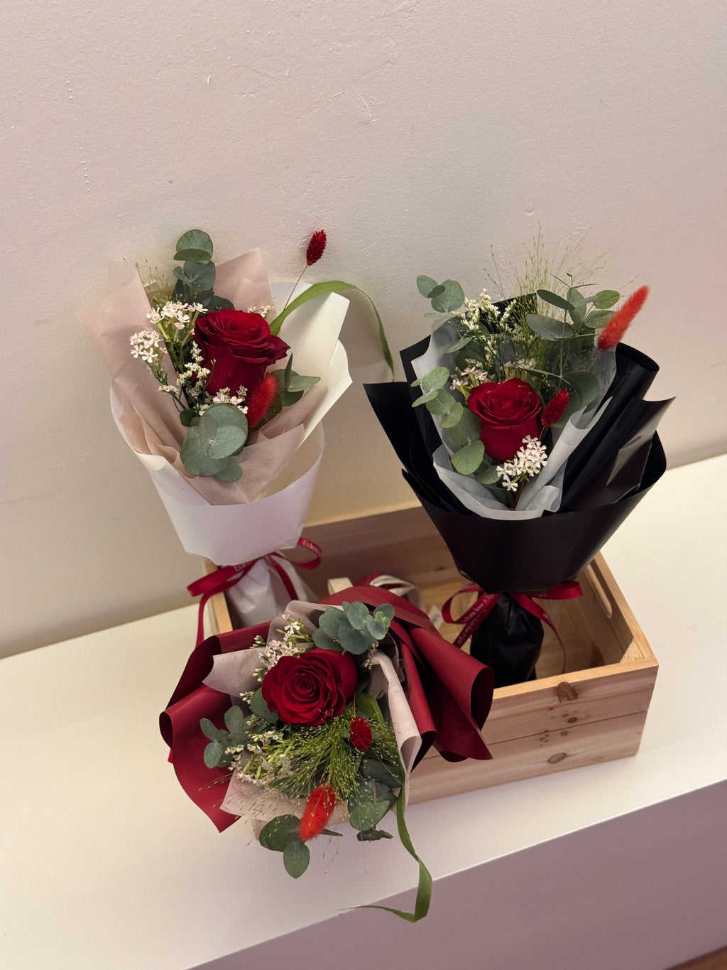 Crimson Garden red roses bouquet wrapped in white, red, or black glassine paper crafted by Eden’s Ground. A classic Valentine's day bouquet.