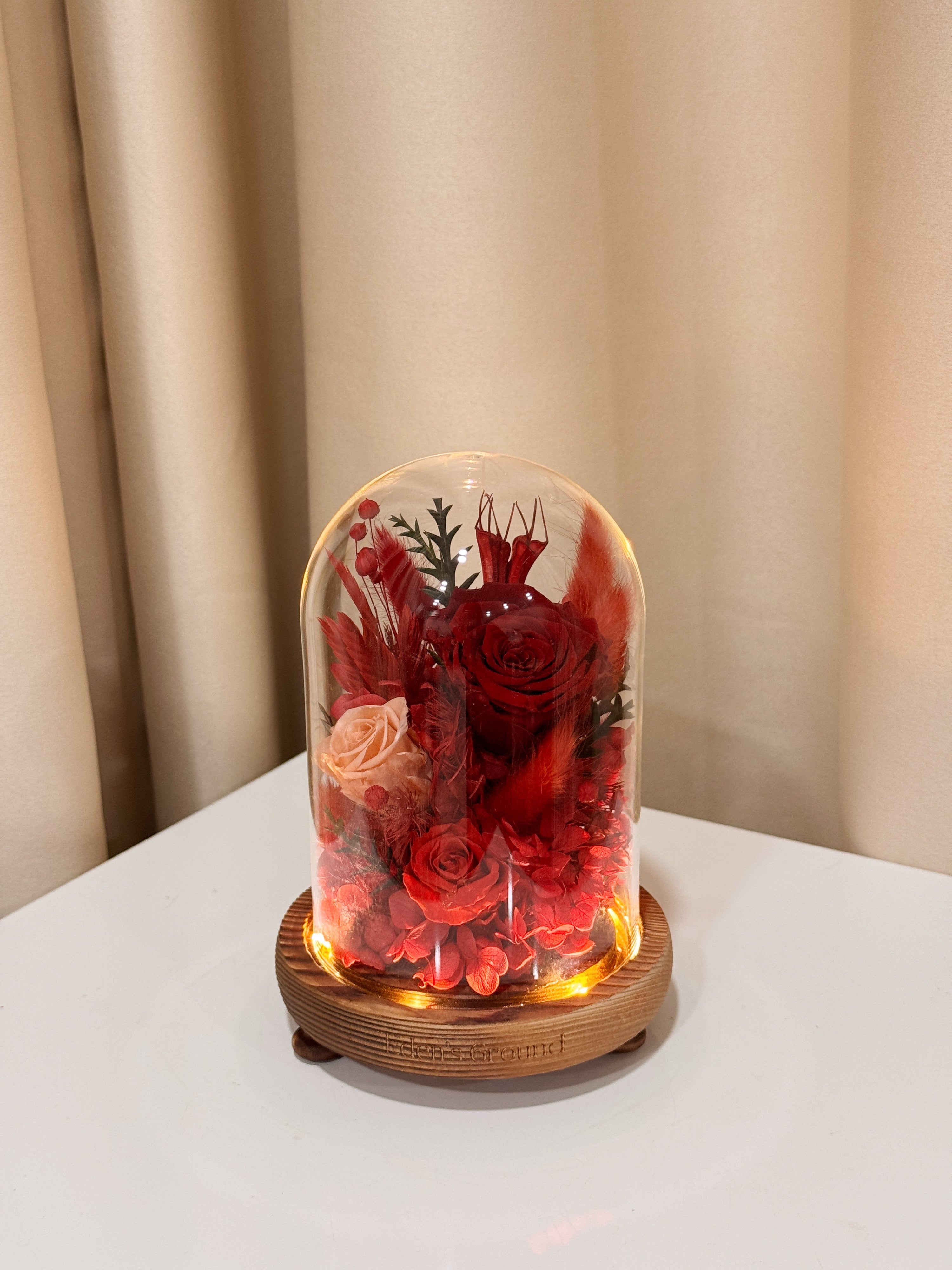 Everlasting Love Flower Dome is made with a delicate blend of preserved red roses, and flowers in a variety of soft pastel colours, beautifully arranged in a glass dome by Eden’s Ground—an unforgettable gift or home decor made to last. 