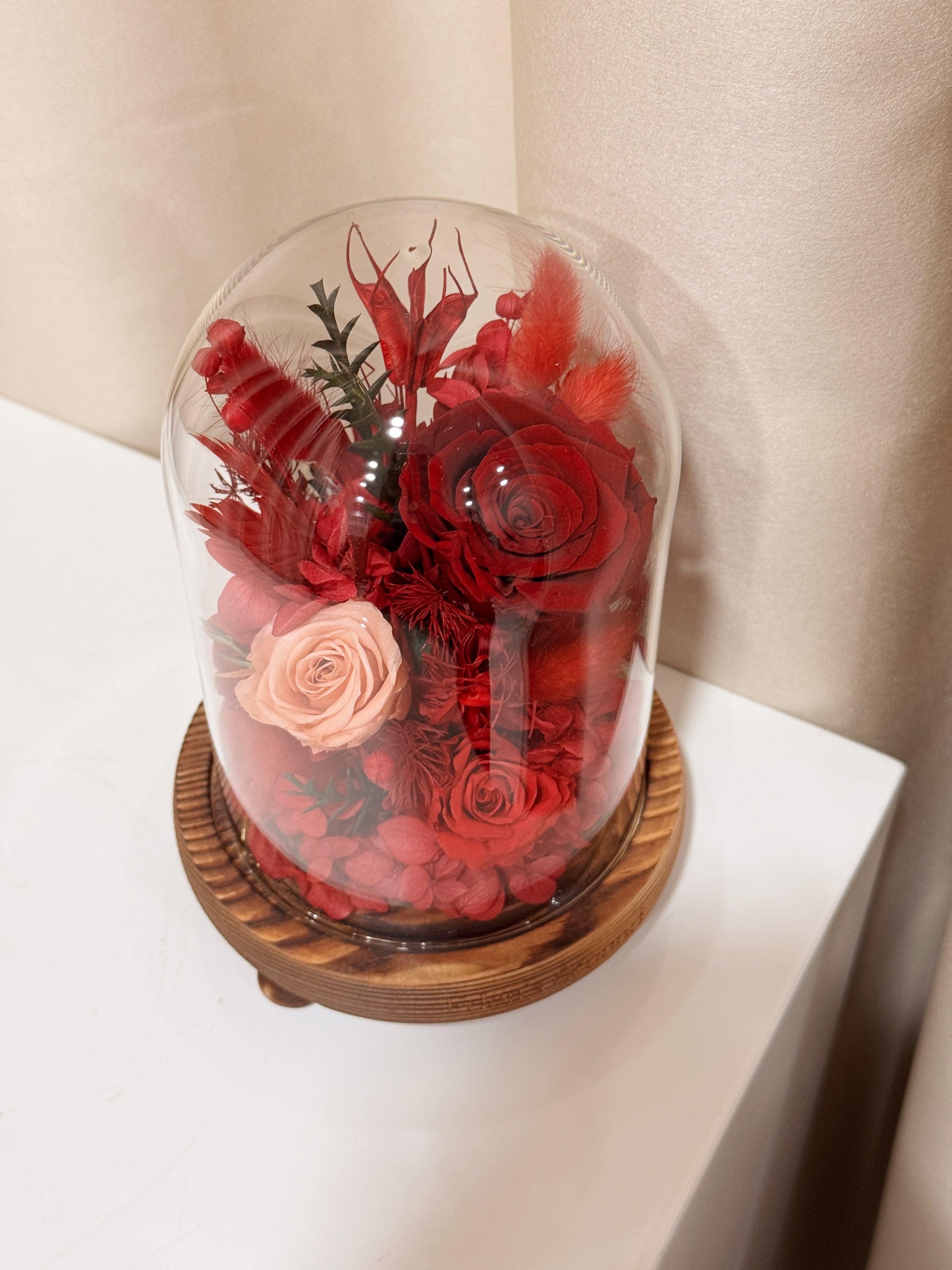 Everlasting Love Flower Dome is made with a delicate blend of preserved red roses, and flowers in a variety of soft pastel colours, beautifully arranged in a glass dome by Eden’s Ground—an unforgettable gift or home decor made to last. 