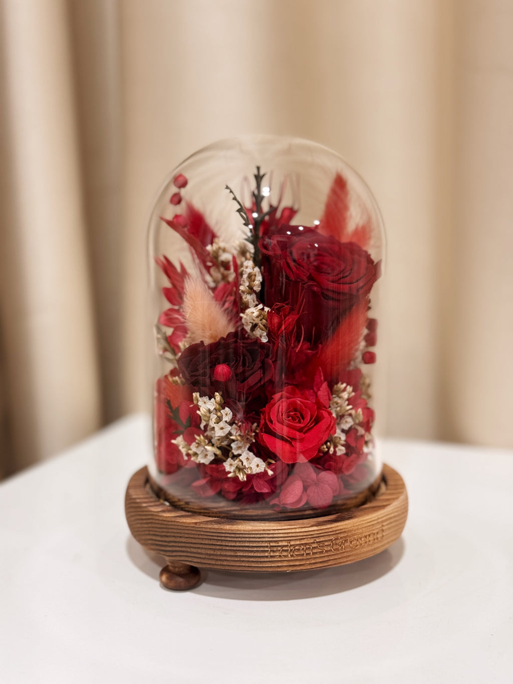 Everlasting Love Flower Dome is made with a delicate blend of preserved red roses, and flowers in a variety of soft pastel colours, beautifully arranged in a glass dome by Eden’s Ground—an unforgettable gift or home decor made to last. 