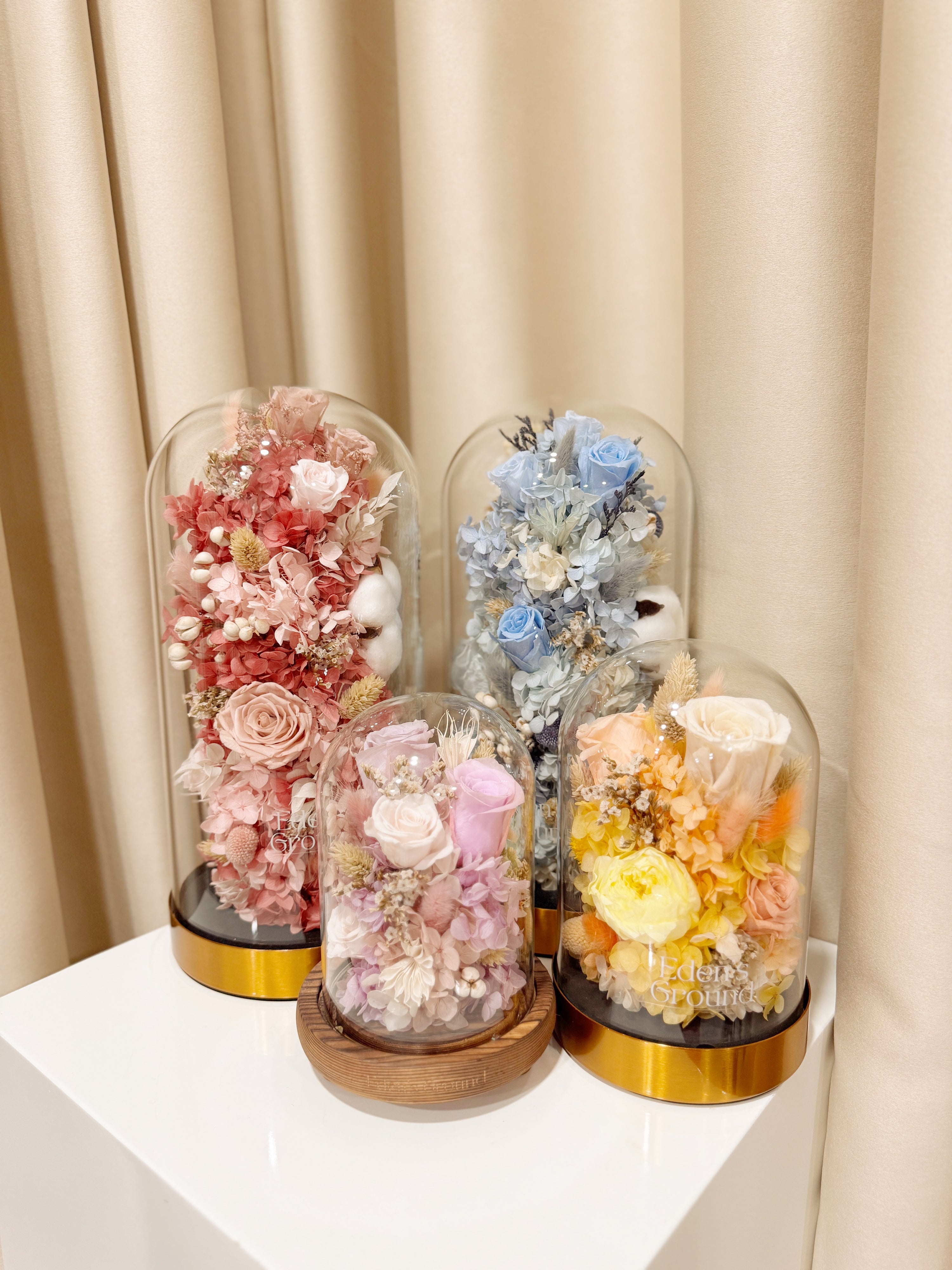 Everlasting Flower Dome is made with a delicate blend of preserved roses, and flowers in a variety of soft pastel colours, beautifully arranged in a glass dome by Eden’s Ground—an unforgettable gift or home decor made to last. 
