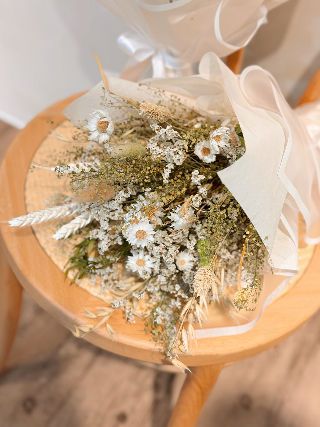 Forest nymph dried flower bouquet made of earth-toned, nature-inspired wildflowers, featuring delicate chamomile daisy and textural foliage, wrapped in glassine paper crafted by Eden’s Ground.