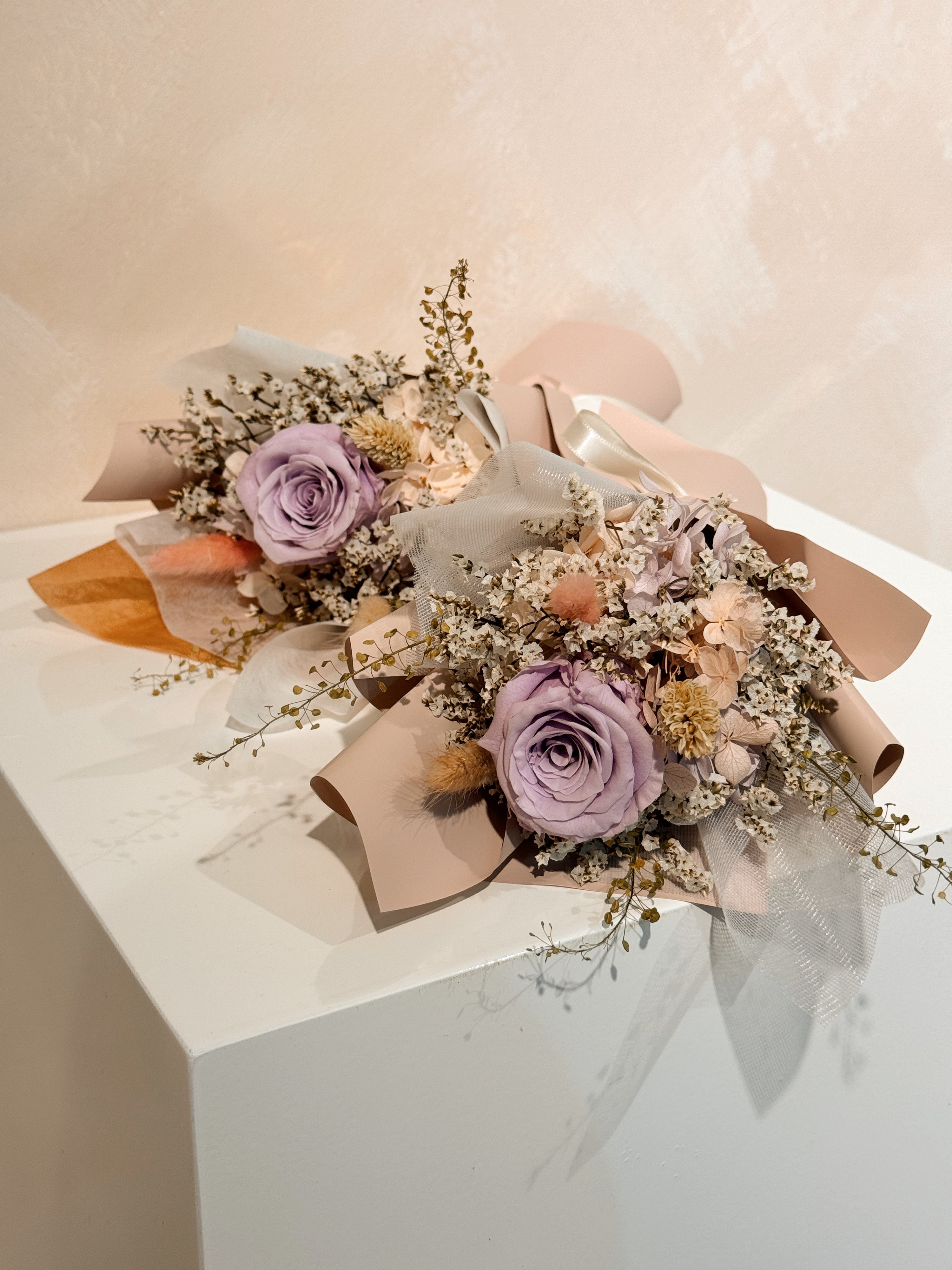 From the heart bouquet, a simple single flower bouquet, featuring either roses or carnation, with hydrangea and various filler flowers, wrapped with white tissue and brown kraft or glassine paper, crafted by Eden's Ground.