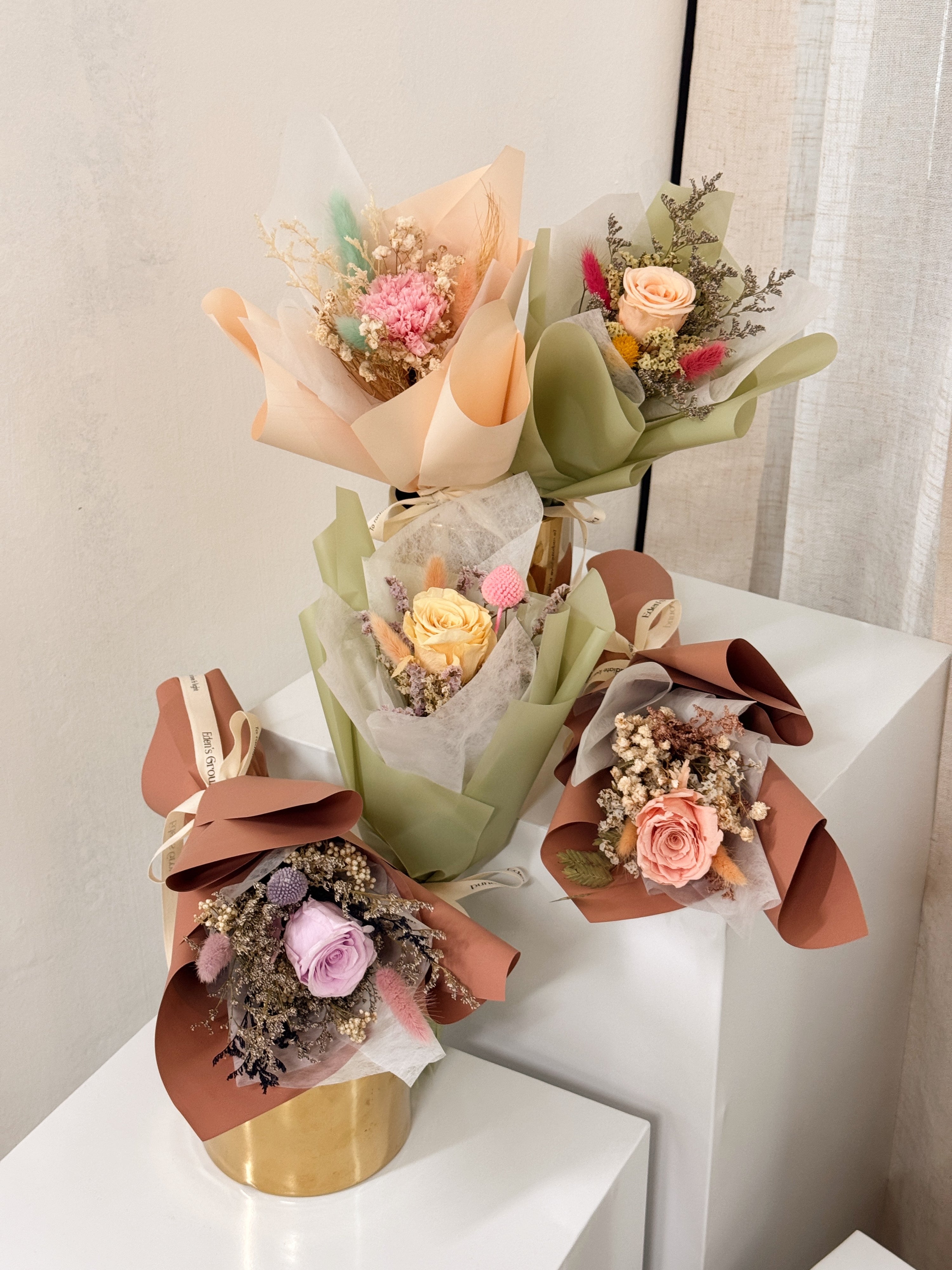 From the bottom of my heart bouquet, a simple single flower bouquet, featuring either roses or carnation, with hydrangea and various filler flowers, wrapped with white tissue and brown kraft or glassine paper, crafted by Eden's Ground.
