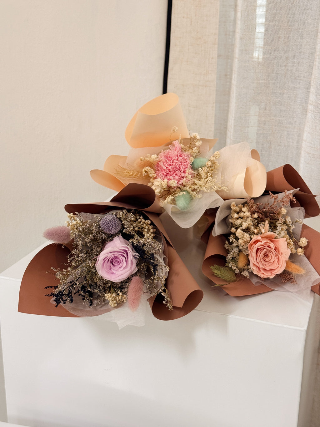 From the bottom of my heart bouquet, a simple single flower bouquet, featuring either roses or carnation, with hydrangea and various filler flowers, wrapped with white tissue and brown kraft or glassine paper, crafted by Eden's Ground.