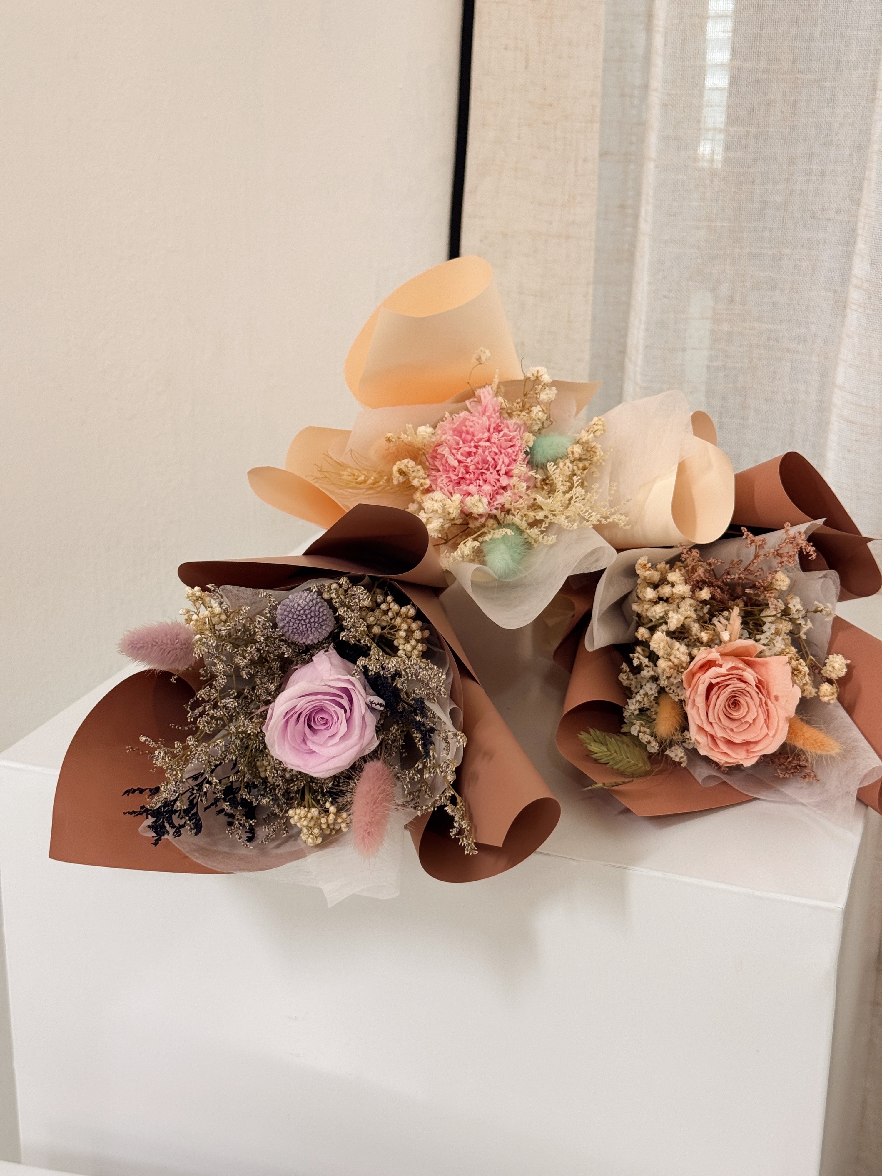 From the bottom of my heart bouquet, a simple single flower bouquet, featuring either roses or carnation, with hydrangea and various filler flowers, wrapped with white tissue and brown kraft or glassine paper, crafted by Eden's Ground.