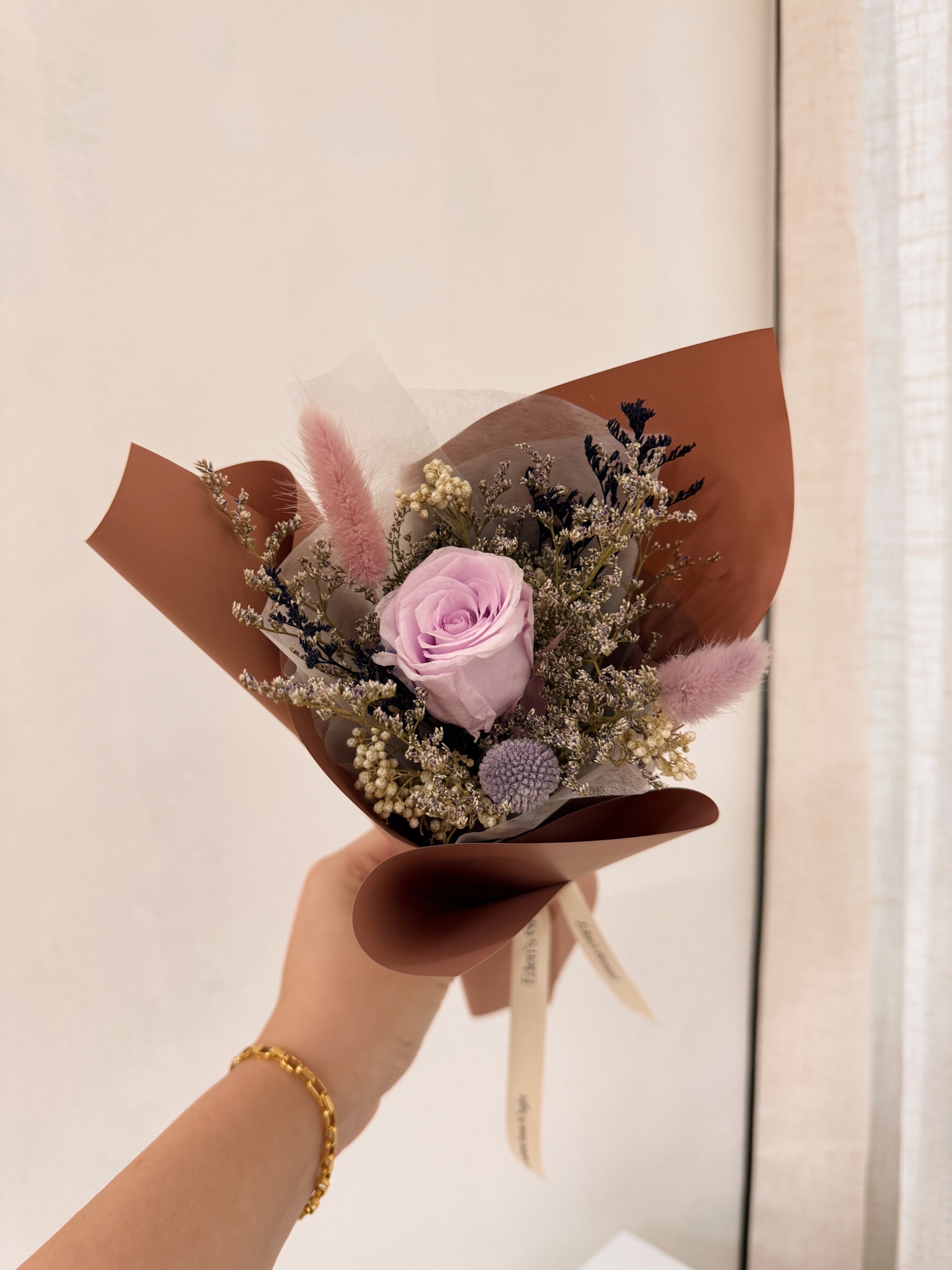 From the bottom of my heart bouquet, a simple single flower bouquet, featuring either roses or carnation, with hydrangea and various filler flowers, wrapped with white tissue and brown kraft or glassine paper, crafted by Eden's Ground.