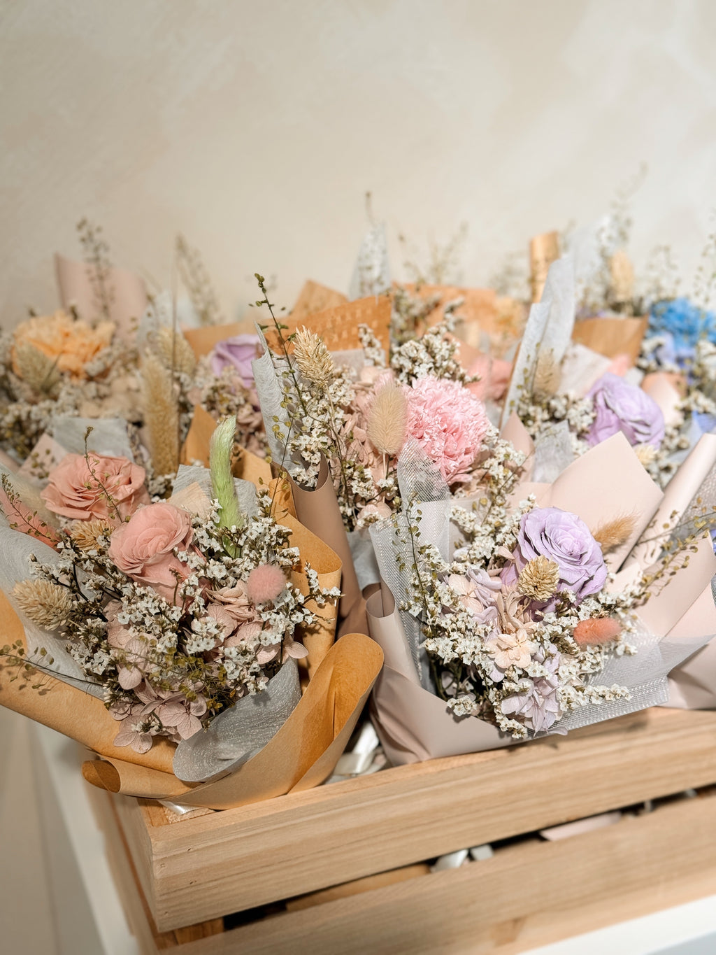 From the heart bouquet, a simple single flower bouquet, featuring either roses or carnation, with hydrangea and various filler flowers, wrapped with white tissue and brown kraft or glassine paper, crafted by Eden's Ground.