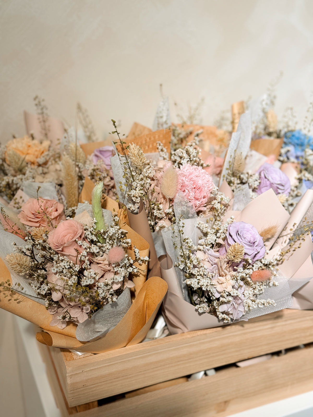From the heart bouquet, a simple single flower bouquet, featuring either roses or carnation, with hydrangea and various filler flowers, wrapped with white tissue and brown kraft or glassine paper, crafted by Eden's Ground.