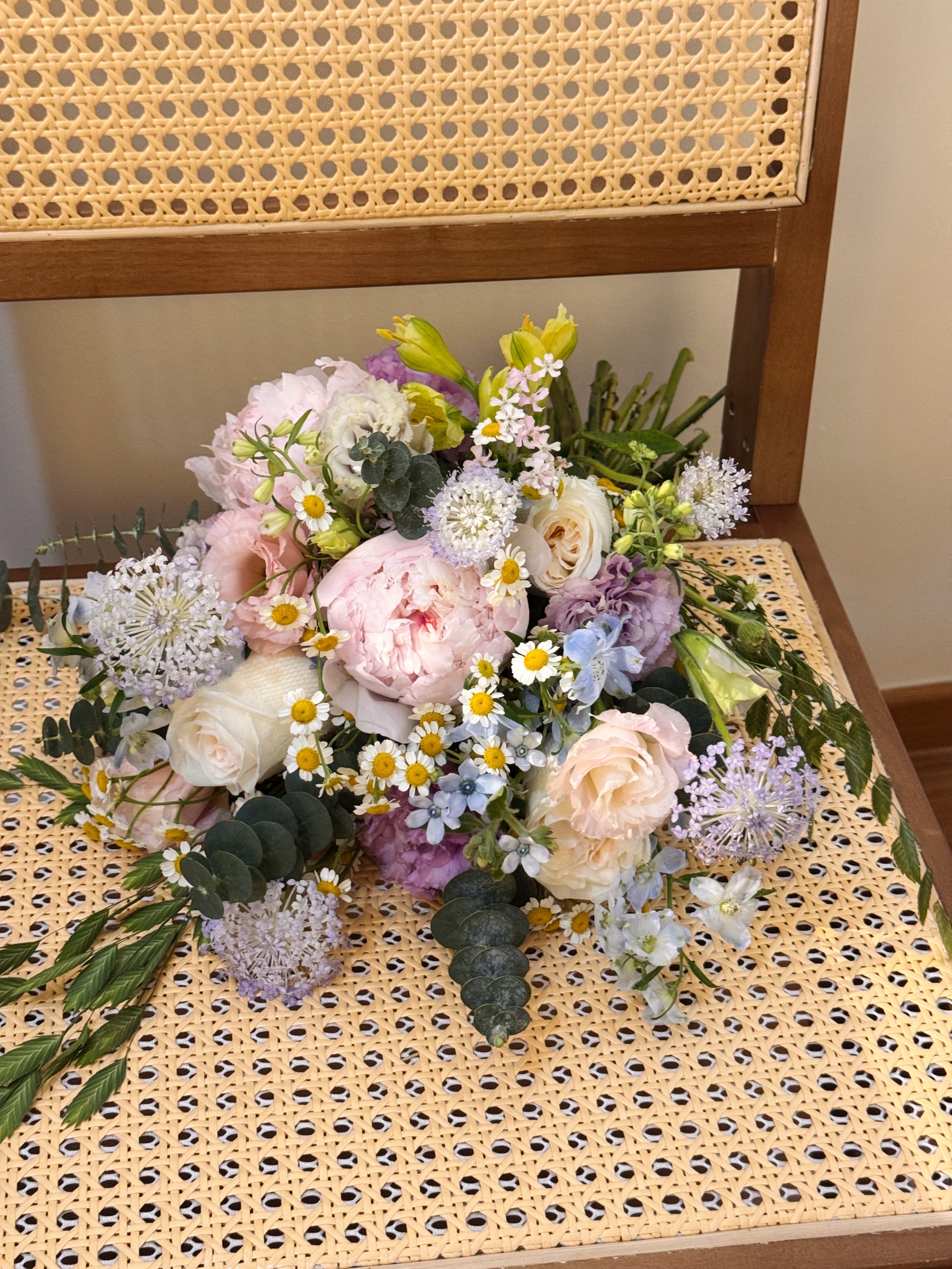 Garden Reverie featuring nature-inspired chamomile daisies, peonies, and a mix of various pastel colour flowers such as roses, eustomas, alstroemeria and eucalyptus, wrapped in tissue paper and white glassine paper crafted by Eden’s Ground.