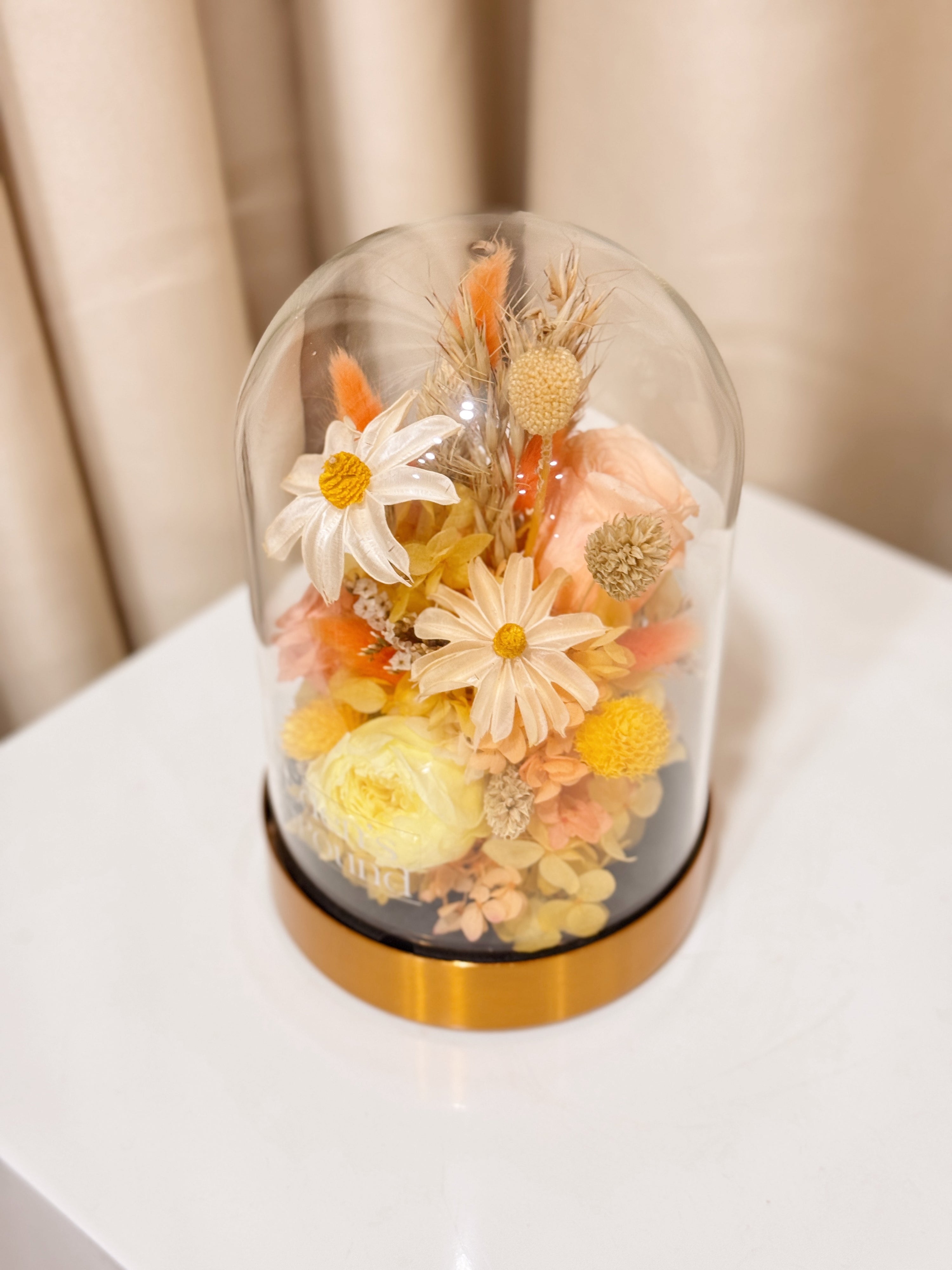 Everlasting Lemon Meringue Flower Dome is made with a delicate blend of preserved cheerful yellow roses, and flowers in a variety of soft pastel colours, beautifully arranged in a glass dome by Eden’s Ground—an unforgettable gift or home decor made to last. 