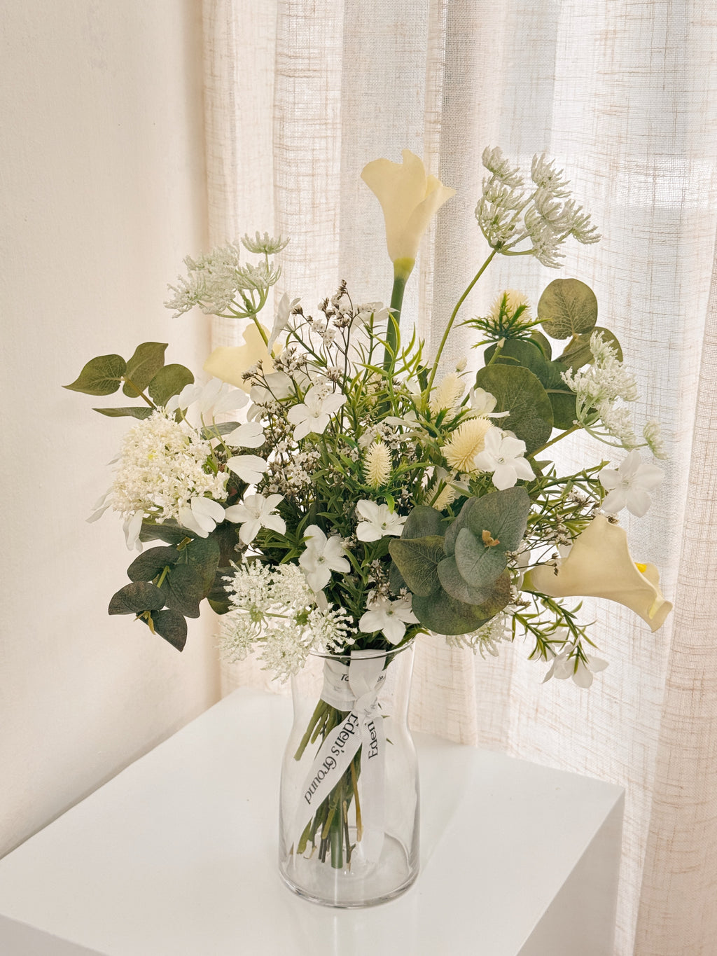 Pearl Veil Faux Flower vase arrangement by Eden’s Ground featuring life like fake flowers in soft white, earthy green tones — thoughtfully styled in a vase. Low-maintenance and long-lasting, it's perfect as a housewarming gift or as a timeless piece of home décor.