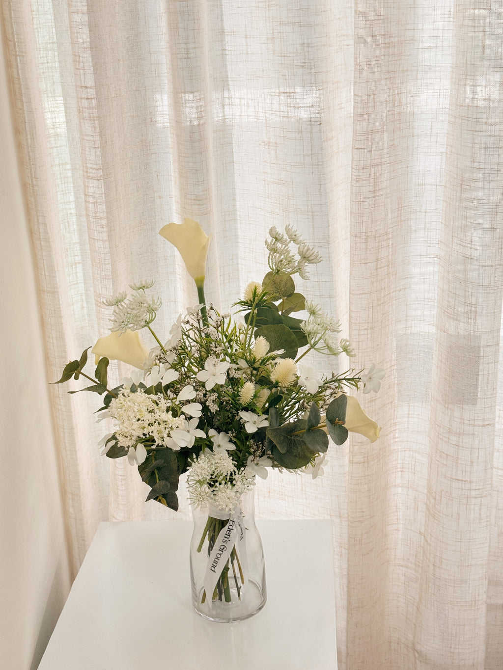 Pearl Veil Faux Flower vase arrangement by Eden’s Ground featuring life like fake flowers in soft white, earthy green tones — thoughtfully styled in a vase. Low-maintenance and long-lasting, it's perfect as a housewarming gift or as a timeless piece of home décor.