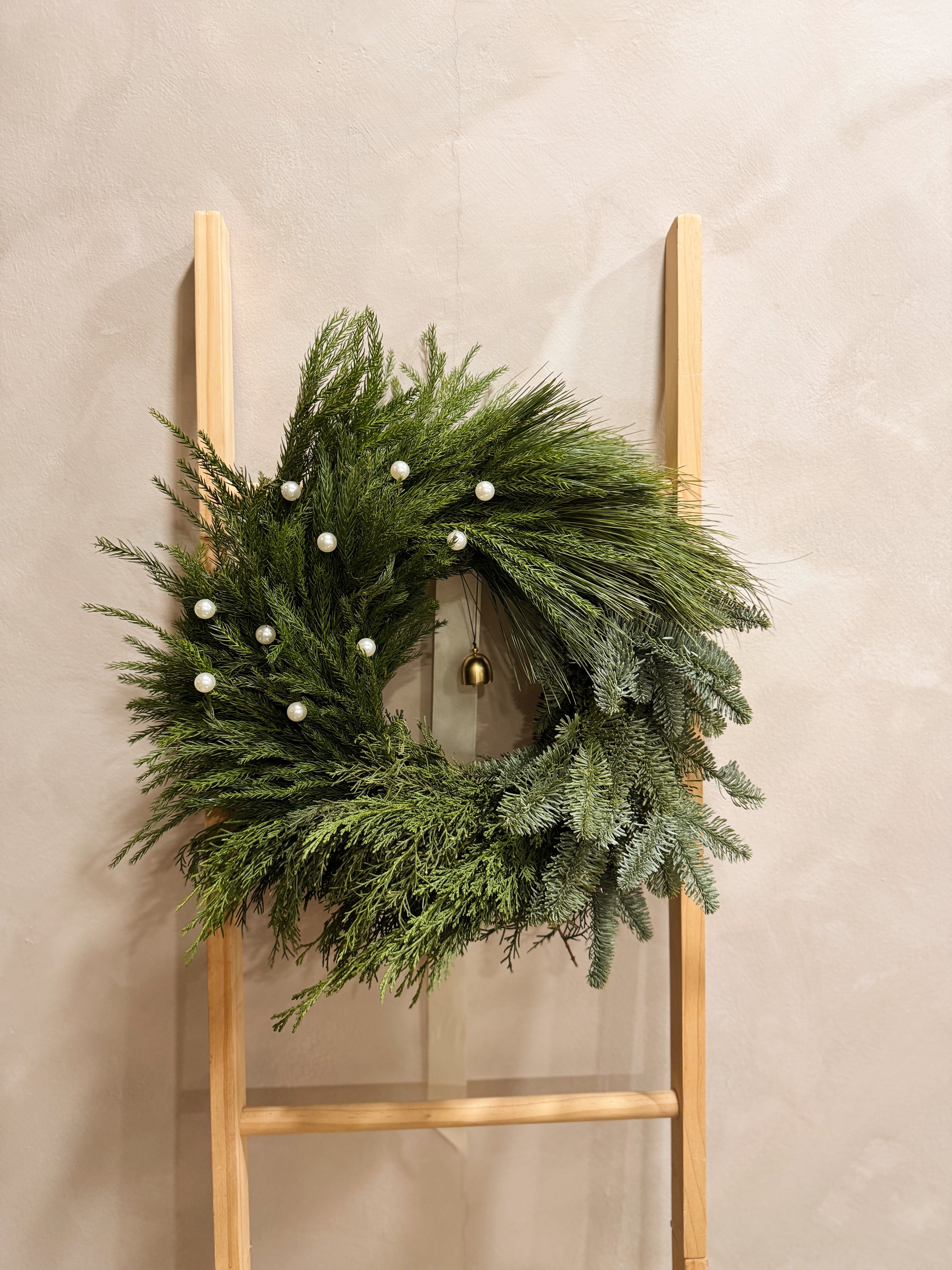 Fresh Christmas Wreath, decorated with pearls and bell by Eden's Ground, a Floral Design Studio in Singapore.