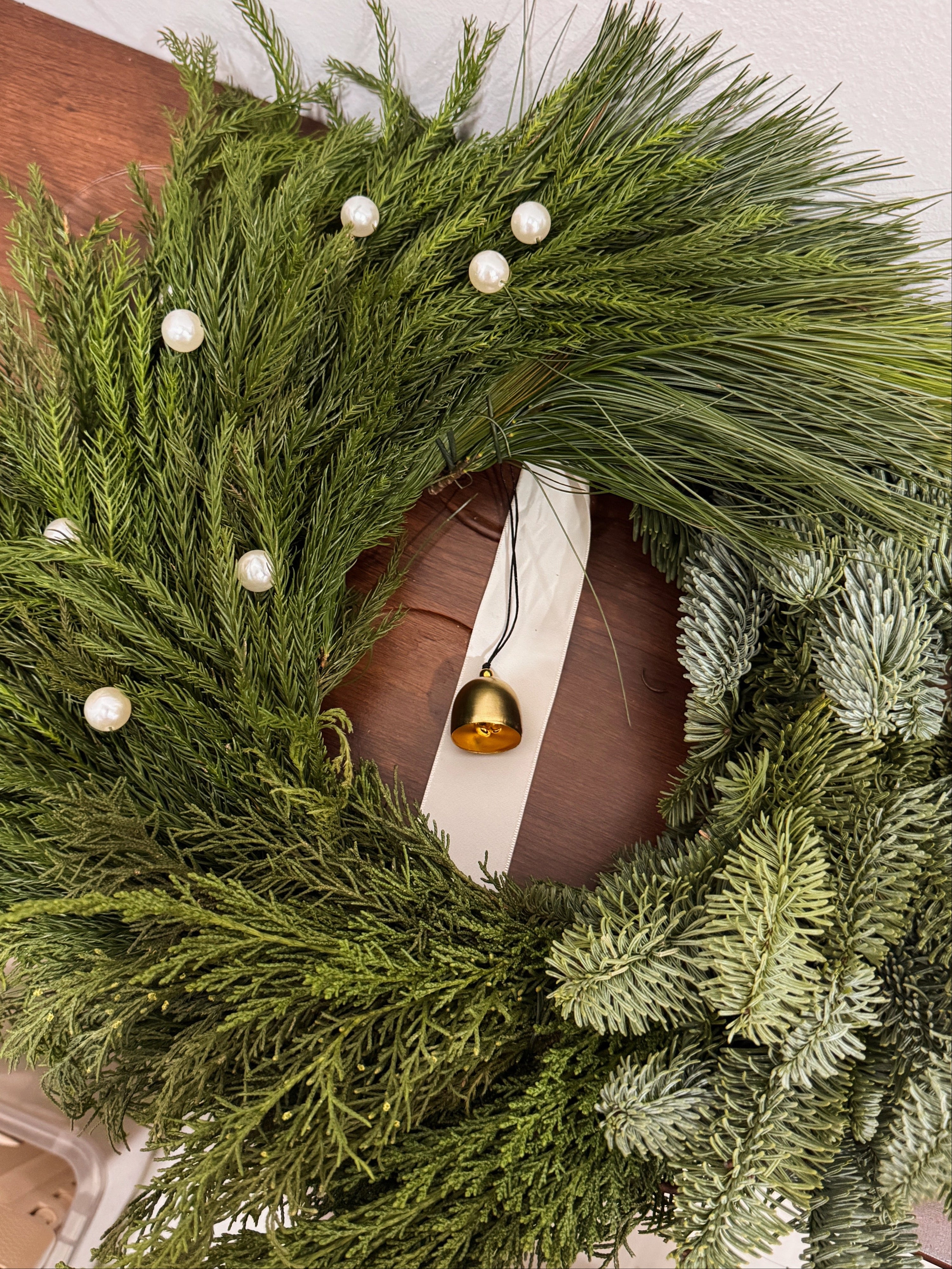 Fresh Christmas Wreath, decorated with pearls and bell by Eden's Ground, a Floral Design Studio in Singapore.
