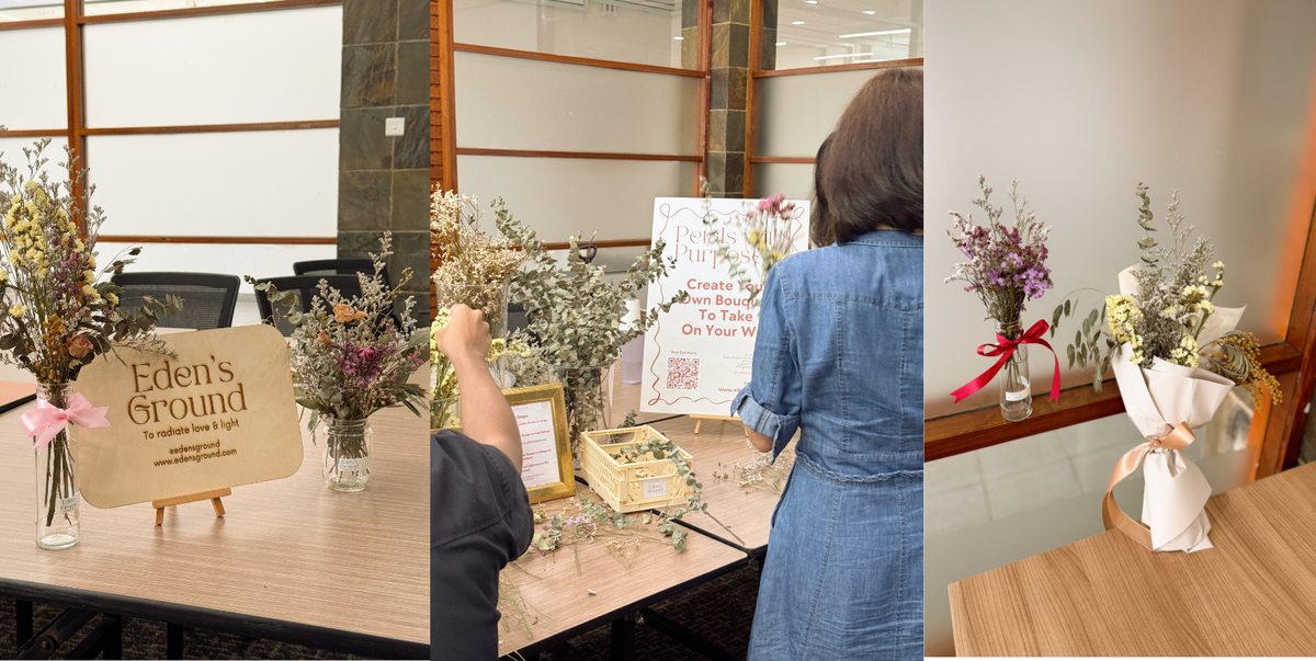 Table with floral arrangements and 'Eden's Ground' sign, person in blue dress interacting with items.