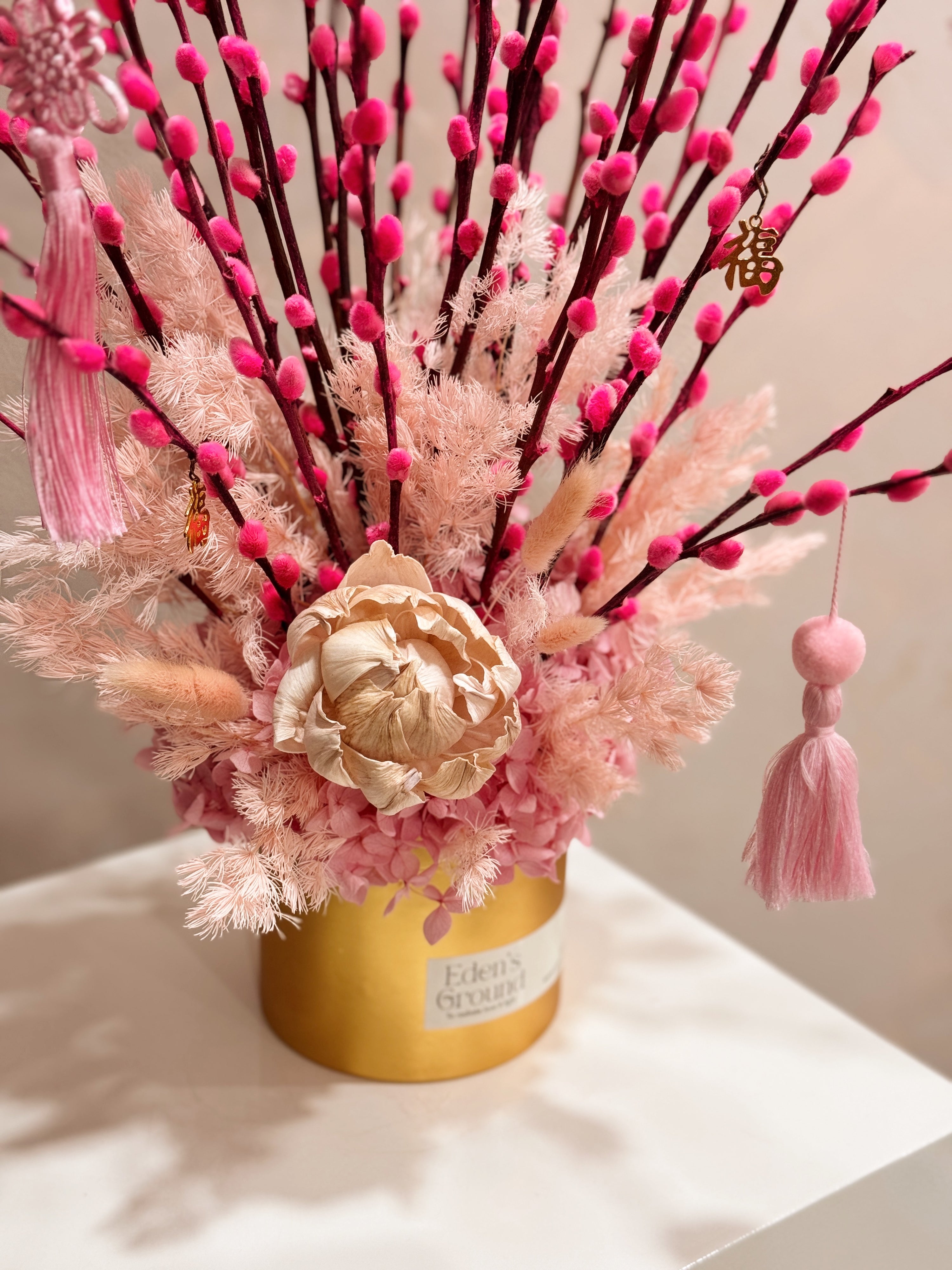 Chinese New Year 2026 Pussy Willow Flower Box, featuring pink and gold pussy willow cny flower, everlasting preserved hydrangeas, decorated with pink tassles and 福 to usher in wealth, abundance, prosperity and all the good vibes for the lunar new year, crafted by Eden's Ground, a floral design studio in Singapore. Delivered straight to your doorstep.