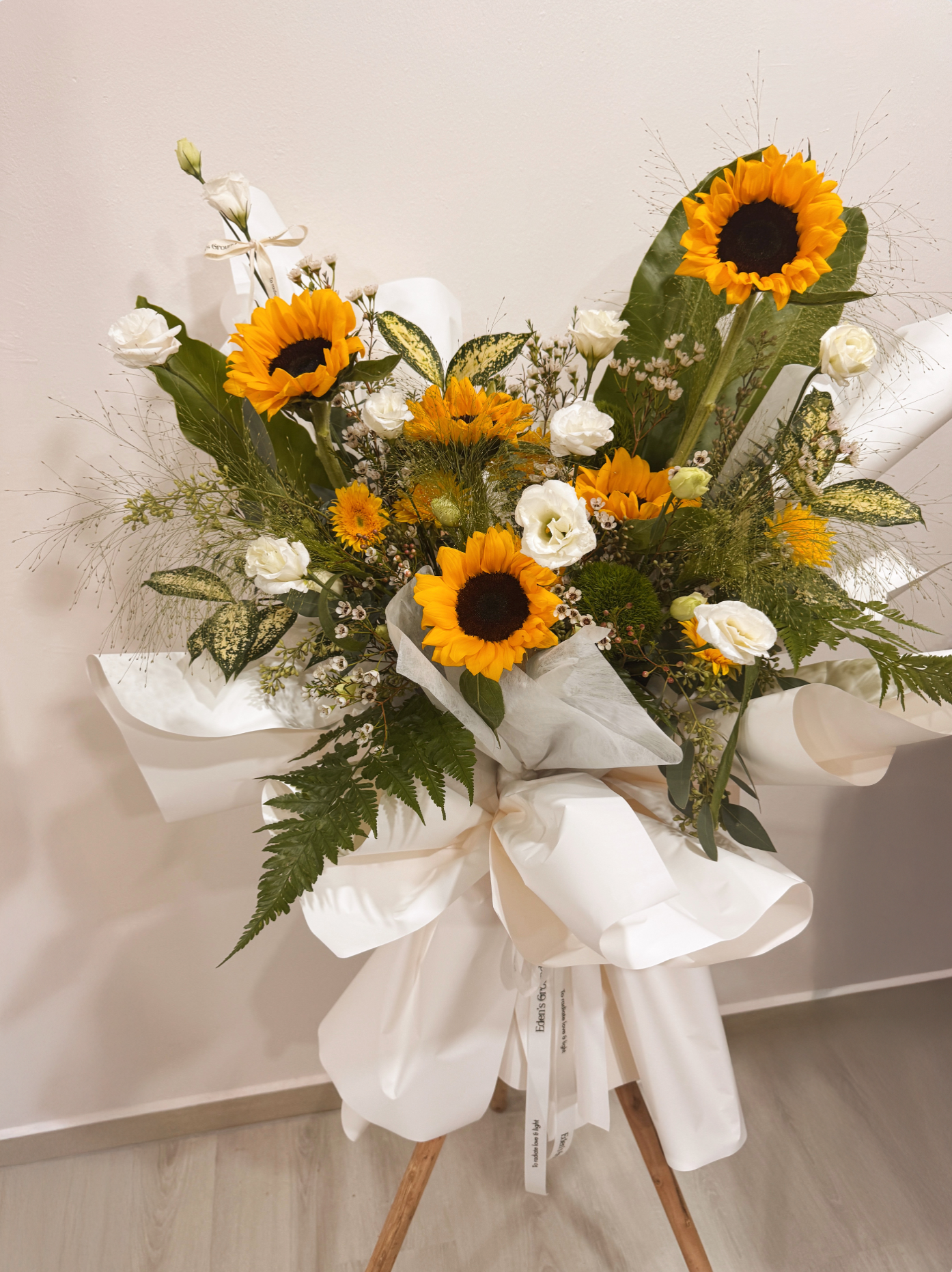 Shining Success Sunflower Congratulatory Stand, featuring vibrant Sunflowers, and the fresh touch of eucalyptus, crafted by Eden's Ground, a floral design boutique based in Singapore.