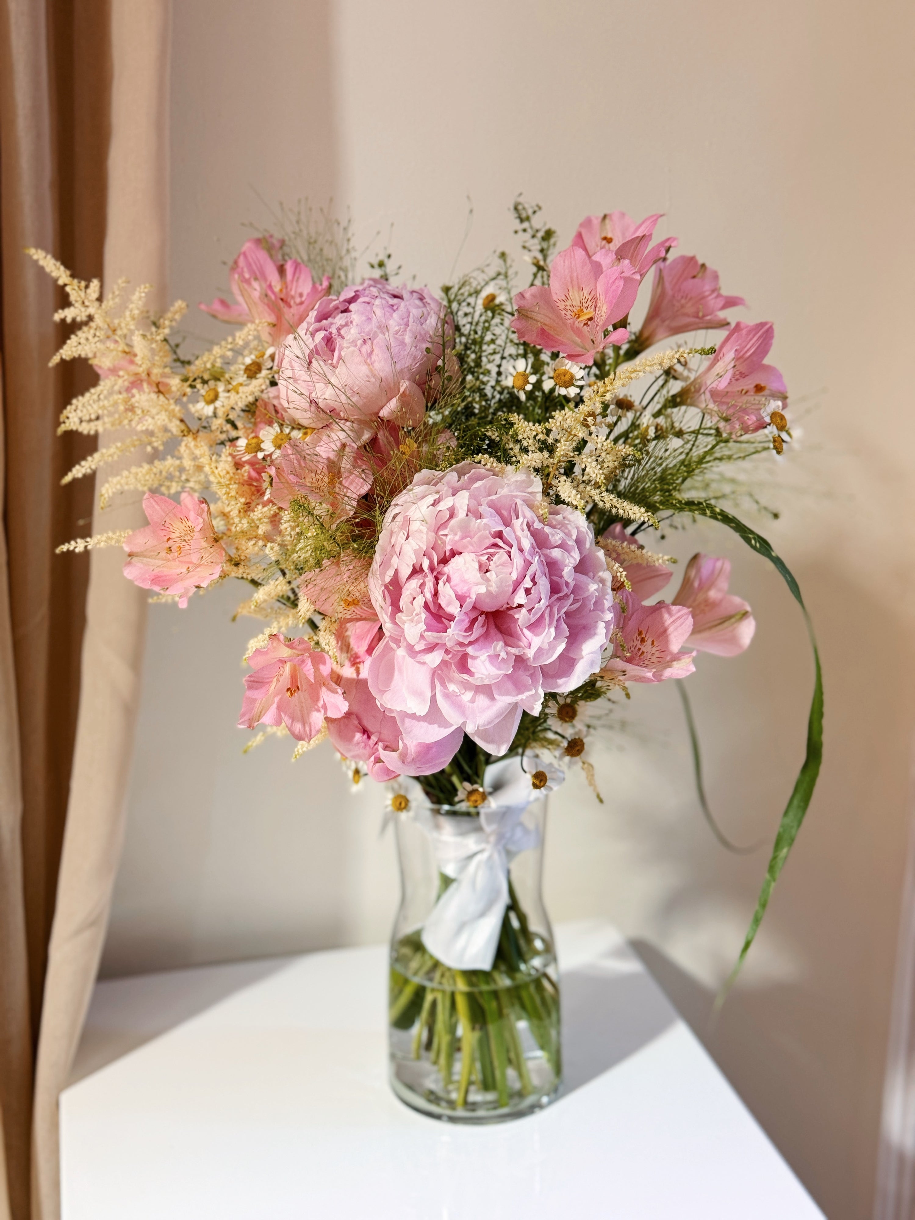 Sweeter Than Honeycomb pink peony vase arrangement featuring luxury peonies and a mix of textural foliage, wrapped in tissue paper and white glassine paper crafted by Eden’s Ground.
