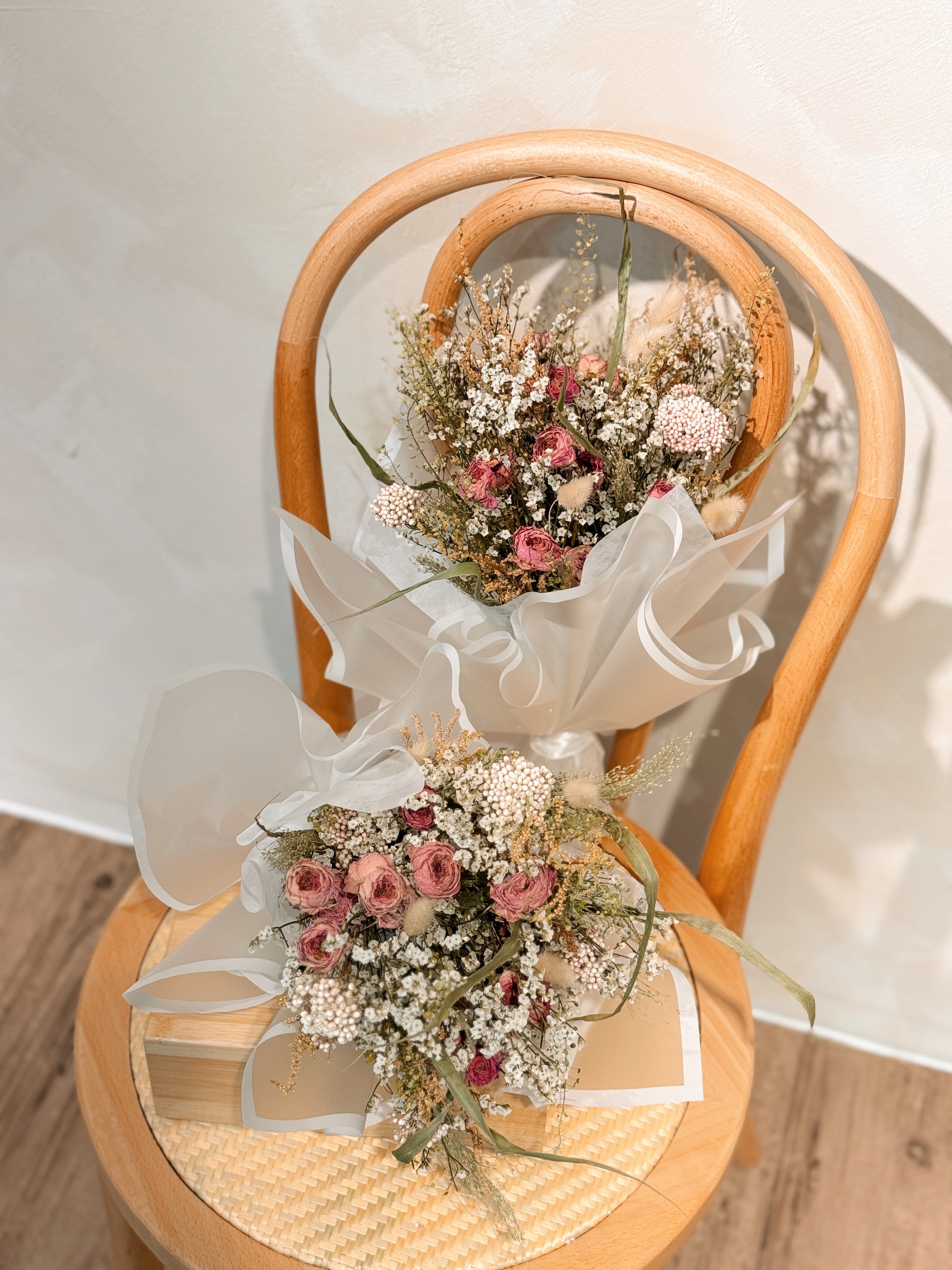 Tide of your great love, romantic dried flower bouquet featuring sweet pink roses, and textural foliage, wrapped in glassine paper crafted by Eden’s Ground.