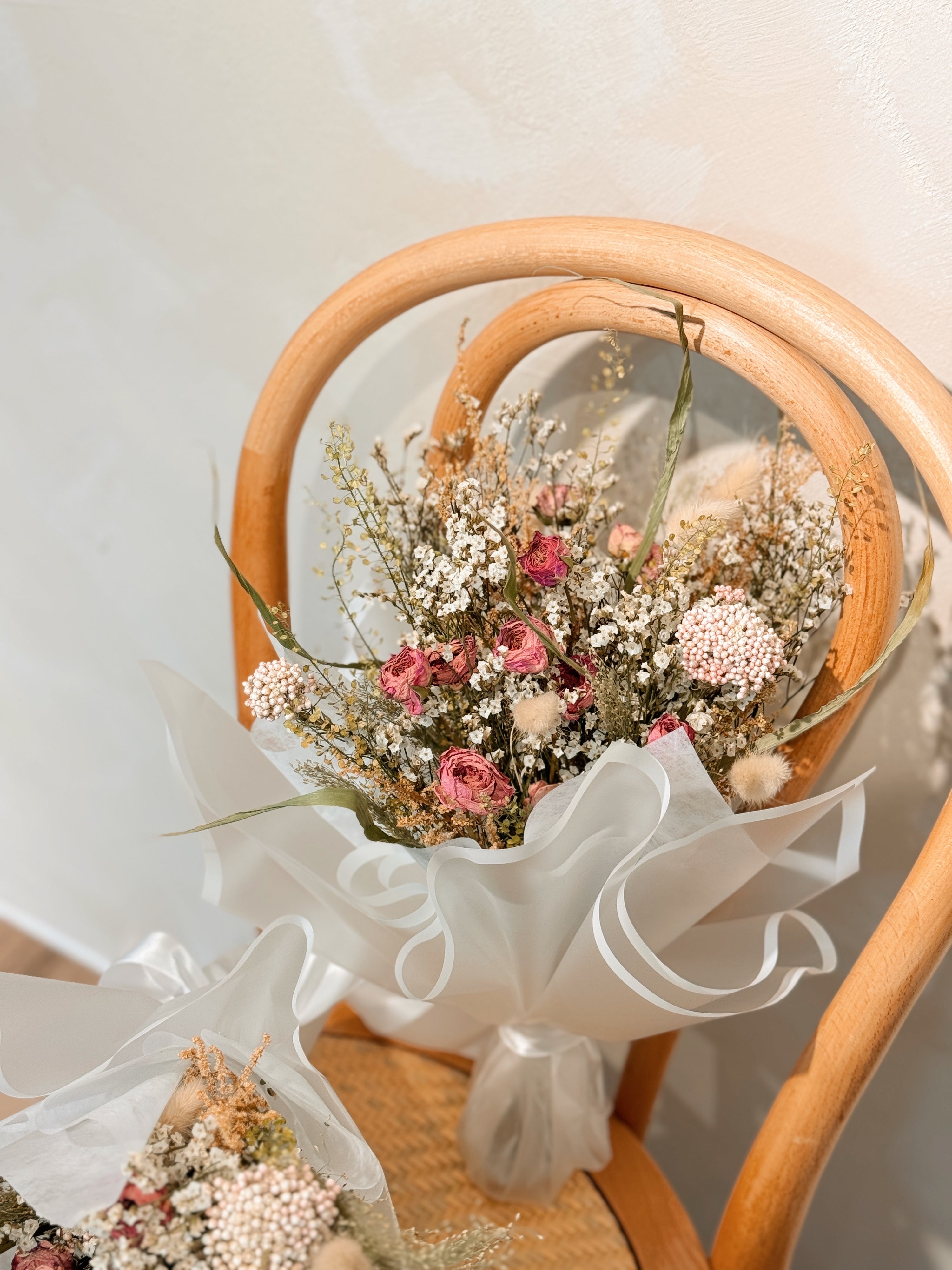 Tide of your great love, romantic dried flower bouquet featuring sweet pink roses, and textural foliage, wrapped in glassine paper crafted by Eden’s Ground.