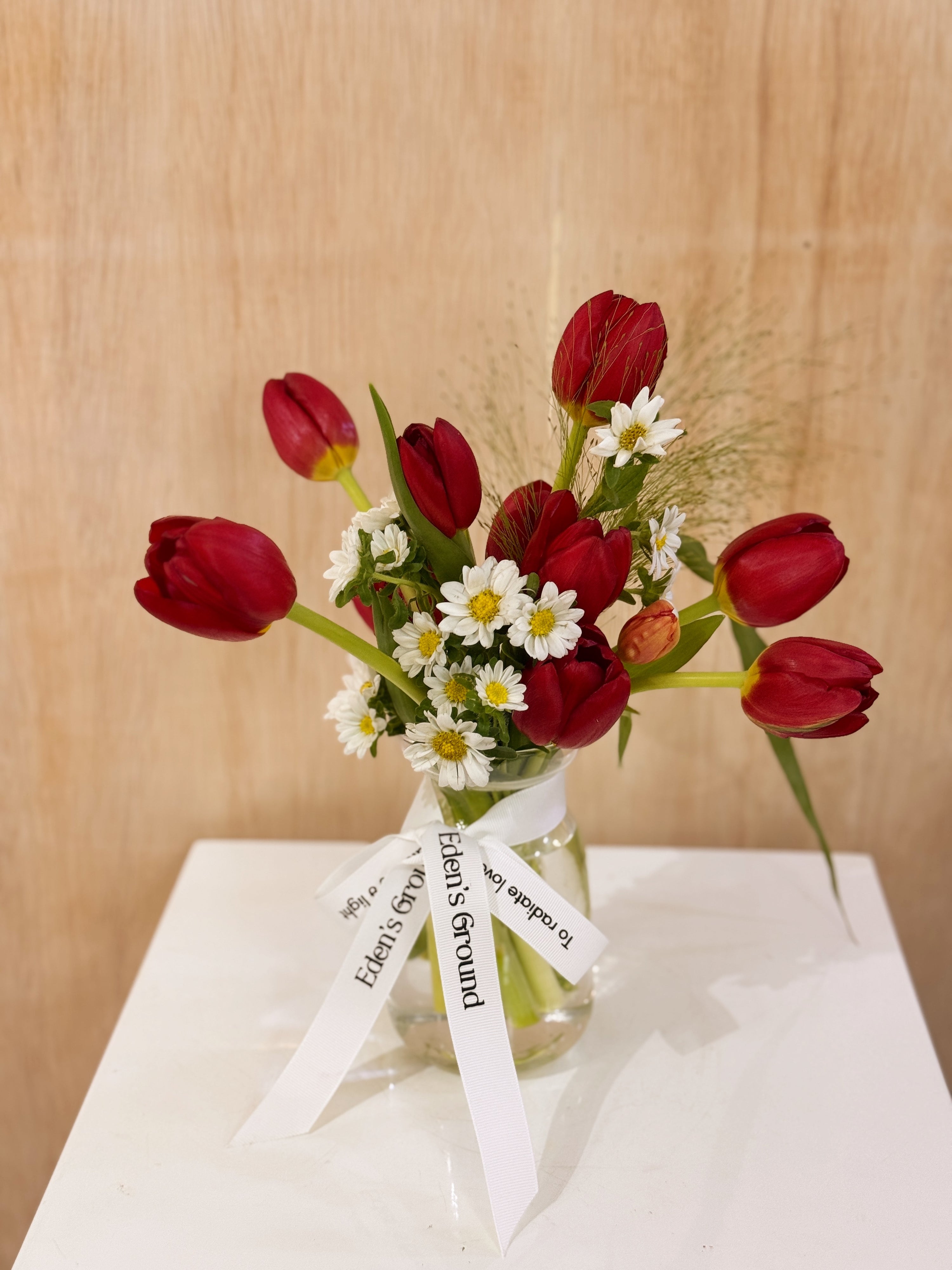 Valentine's tulips in a small vase like jar, featuring vibrant red tulips with lots of daisies crafted by Eden’s Ground, a floral design boutique based in Singapore.
