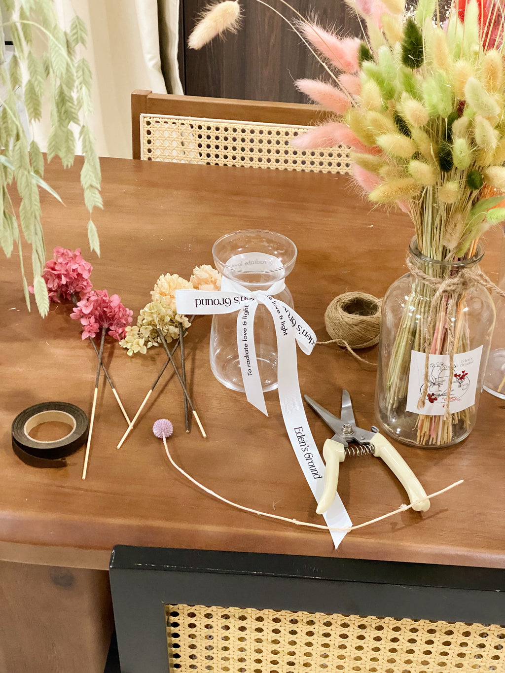 A preserved and dried flower vase arrangement workshop, in soft green and neutral tones. Guided by Eden's Ground, a floral design boutique.