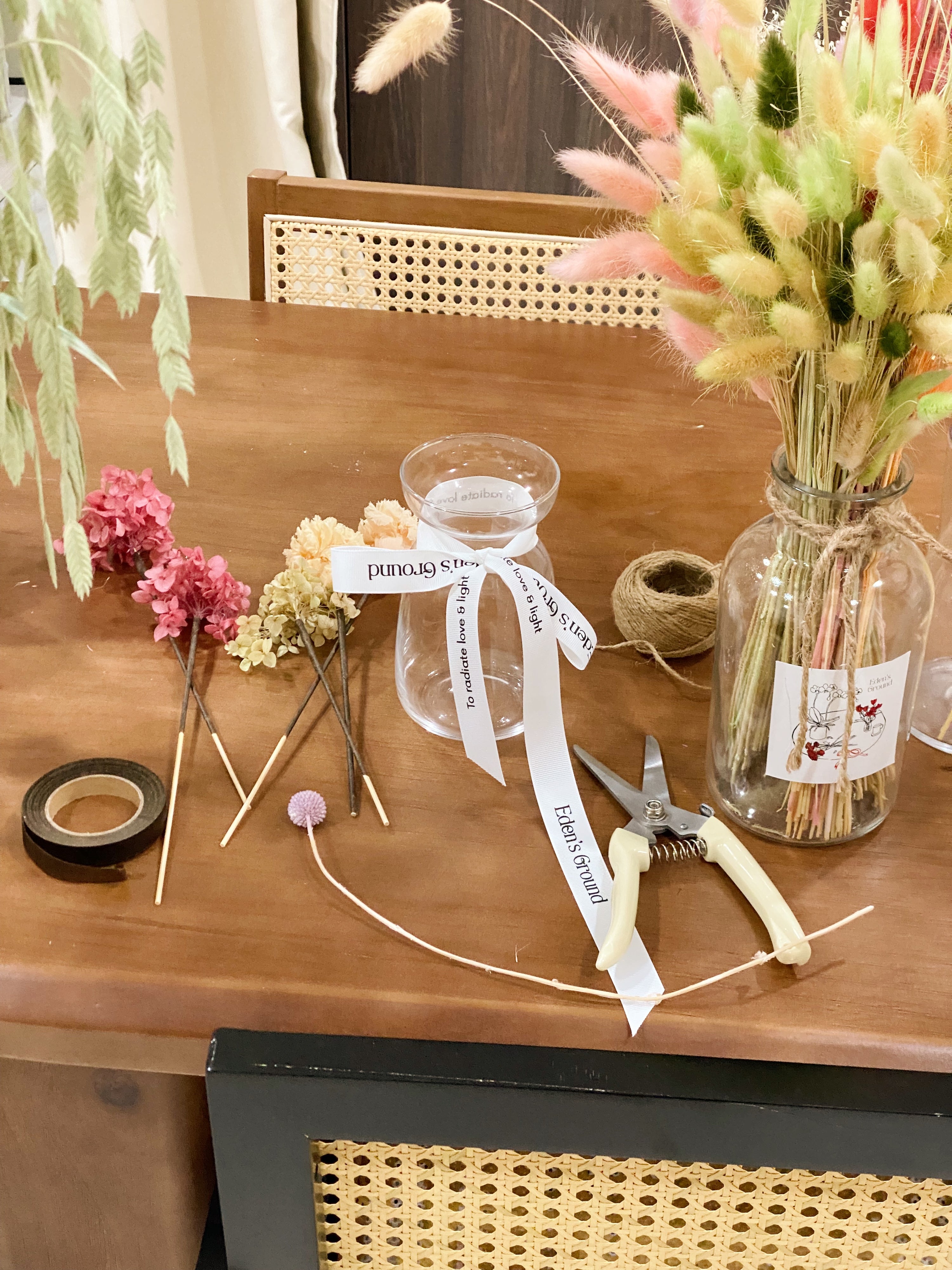 A preserved and dried flower vase arrangement workshop, in soft green and neutral tones. Guided by Eden's Ground, a floral design boutique.