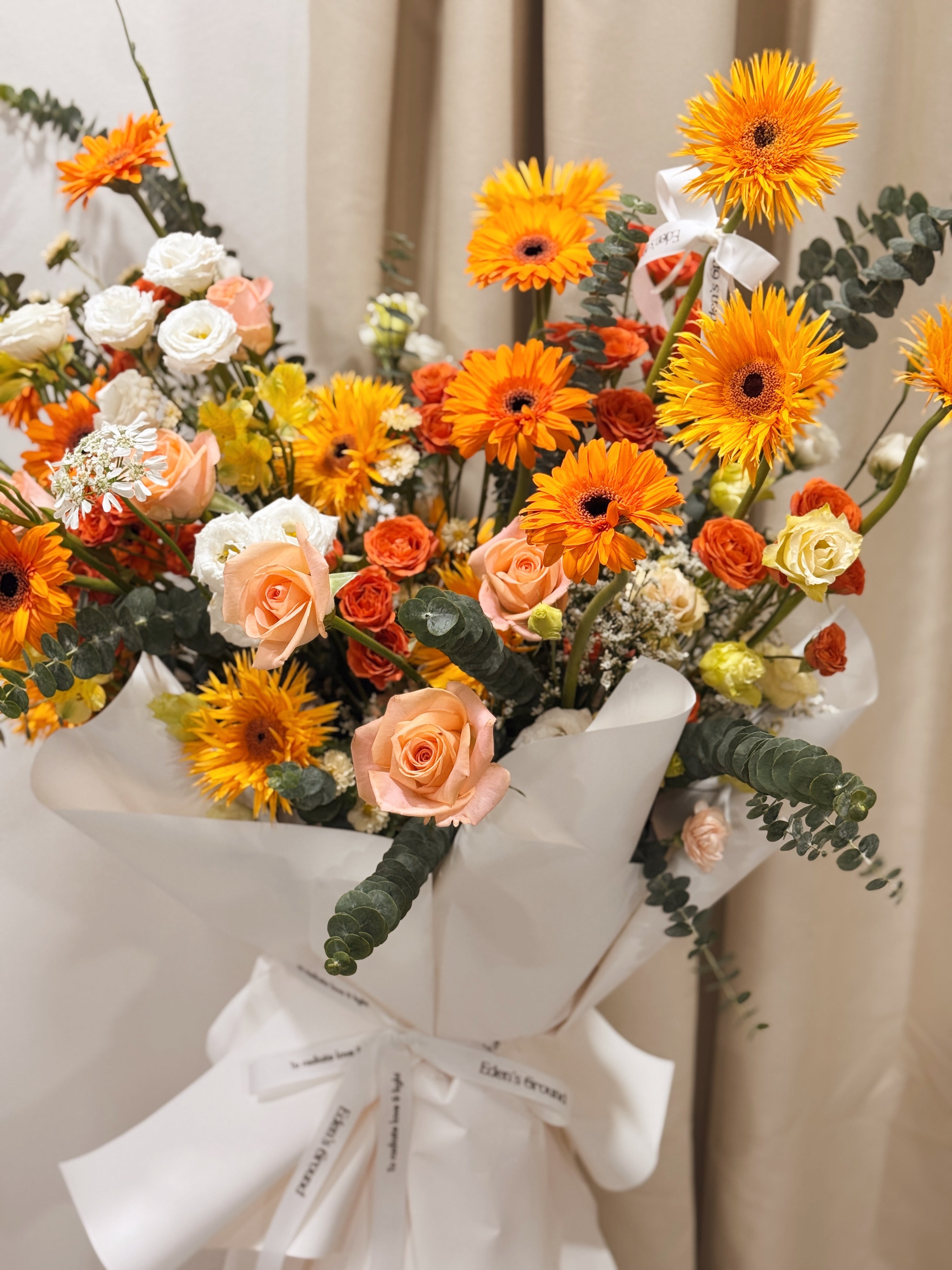 Warmest Congratulations, Fresh Flower Congratulatory Stand, featuring vibrant Roses, cheerful Gerbera, and the fresh touch of eucalyptus, crafted by Eden's Ground, a floral design boutique based in Singapore.