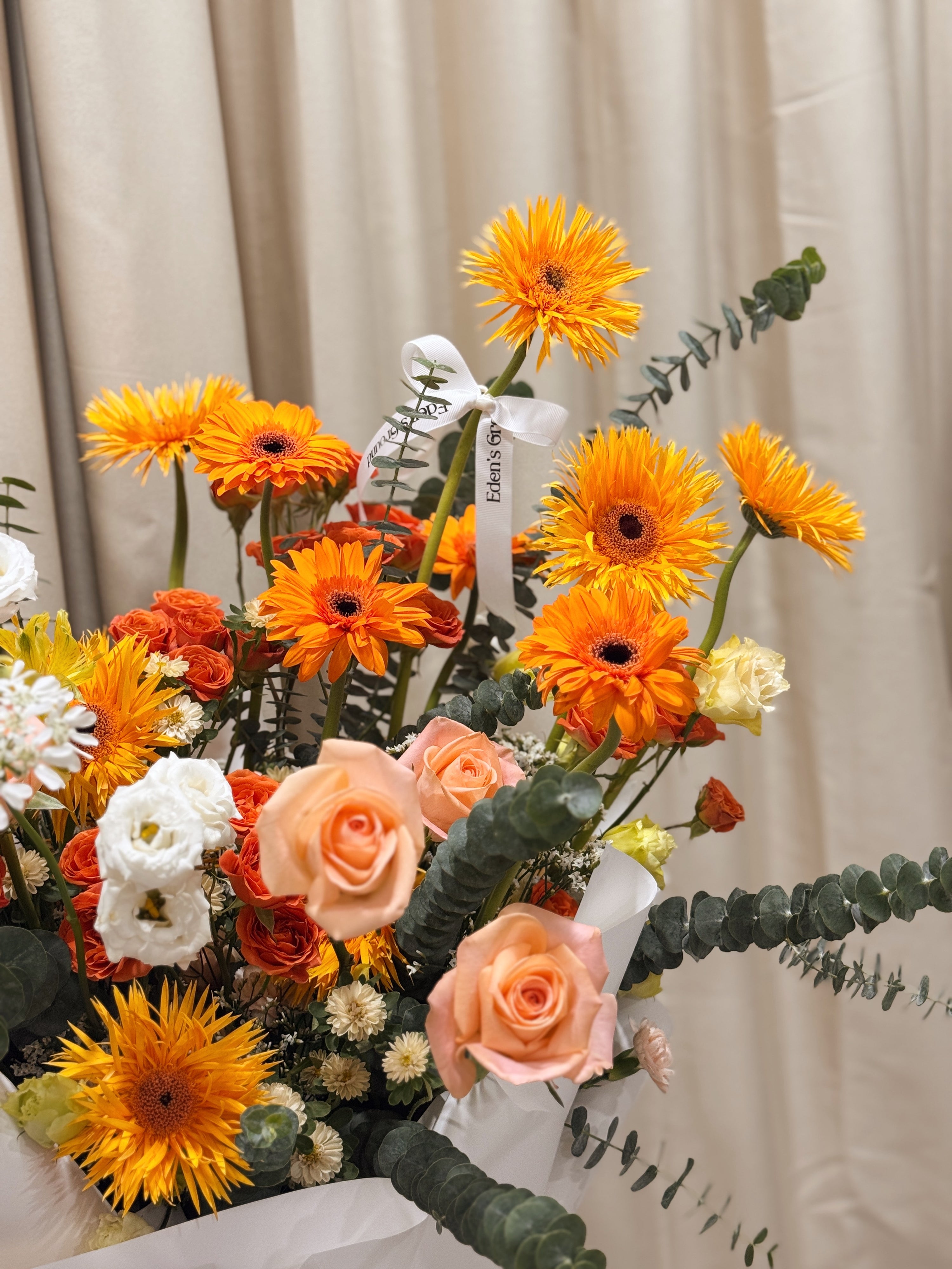 Warmest Congratulations, Fresh Flower Congratulatory Stand, featuring vibrant Roses, cheerful Gerbera, and the fresh touch of eucalyptus, crafted by Eden's Ground, a floral design boutique based in Singapore.