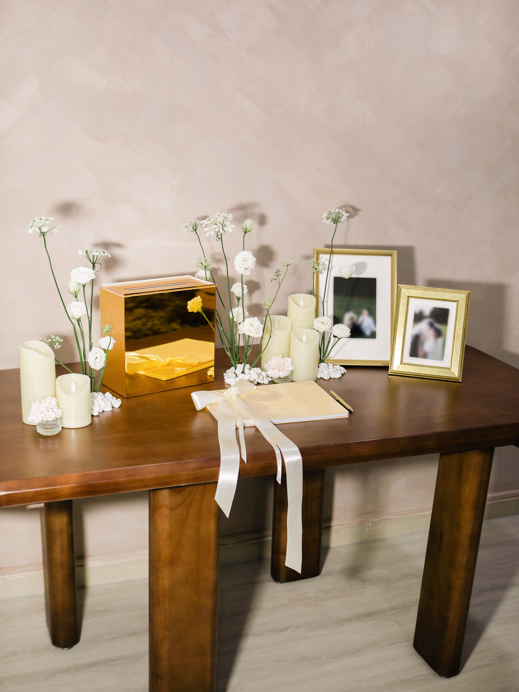 Wedding reception table setting with framed photos, candles, and flowers. Styled by Eden's Ground, a floral design boutique.