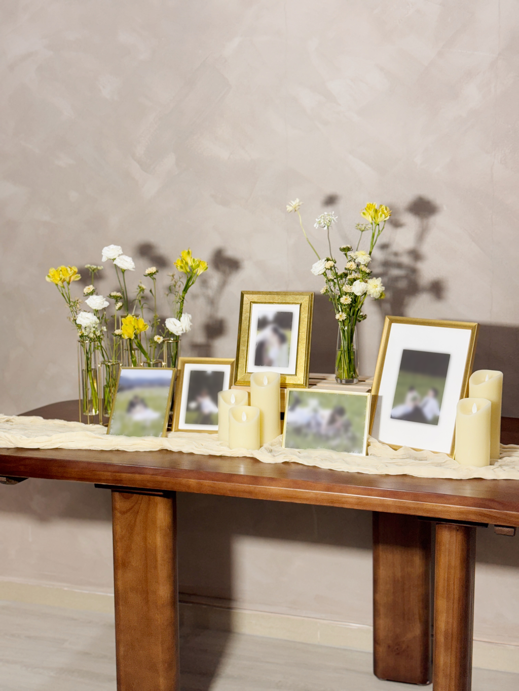 Wedding reception table setting with framed photos, candles, and flowers. Styled by Eden's Ground, a floral design boutique.
