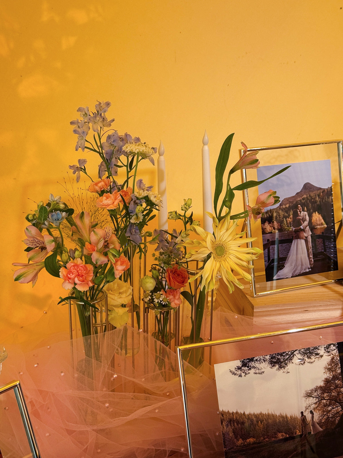 Wedding reception table setting with framed photos, candles, ang bao box, and flowers. Styled by Eden's Ground, a floral design boutique.