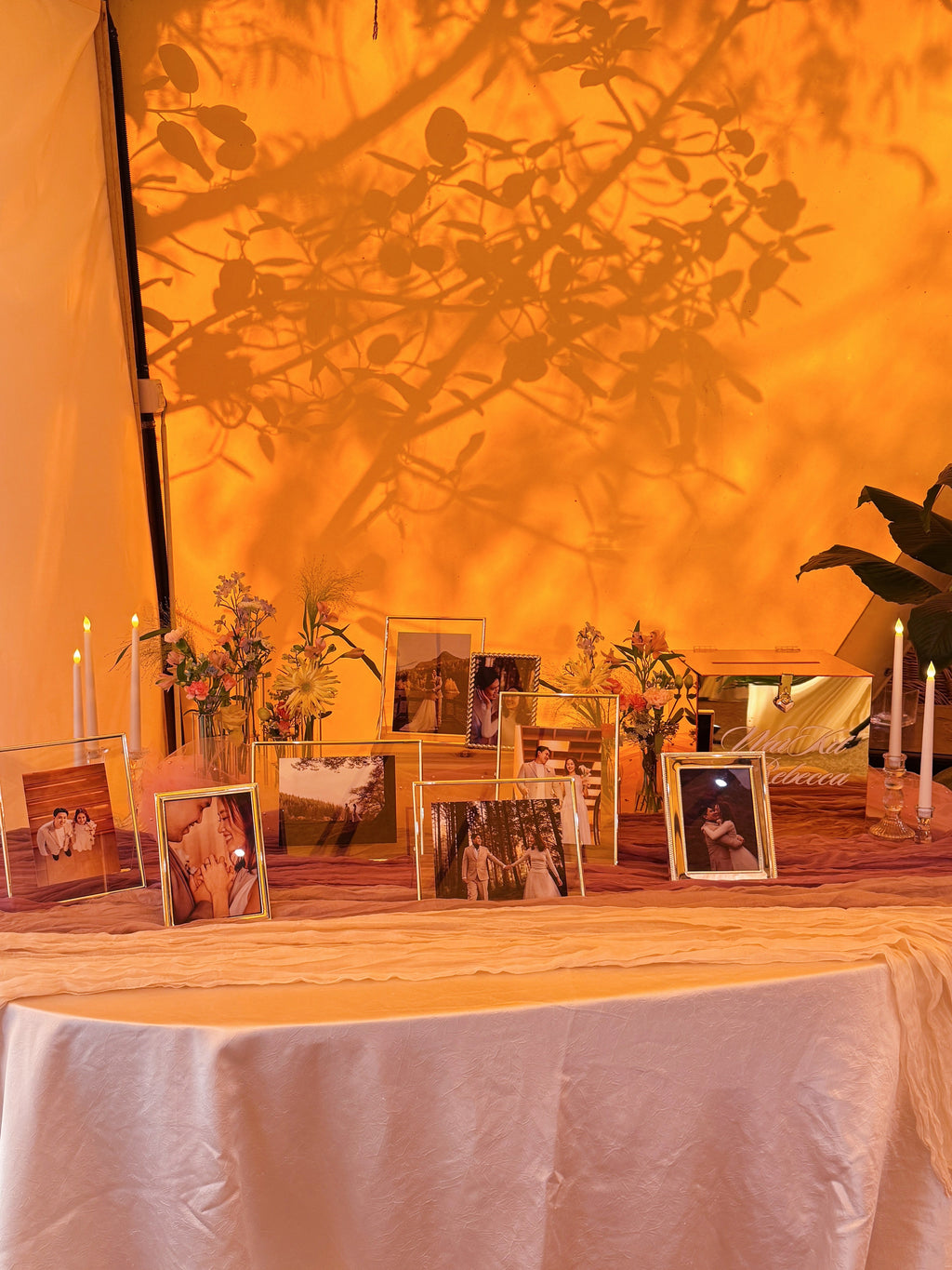Wedding reception table setting with framed photos, candles, ang bao box, and flowers. Styled by Eden's Ground, a floral design boutique.